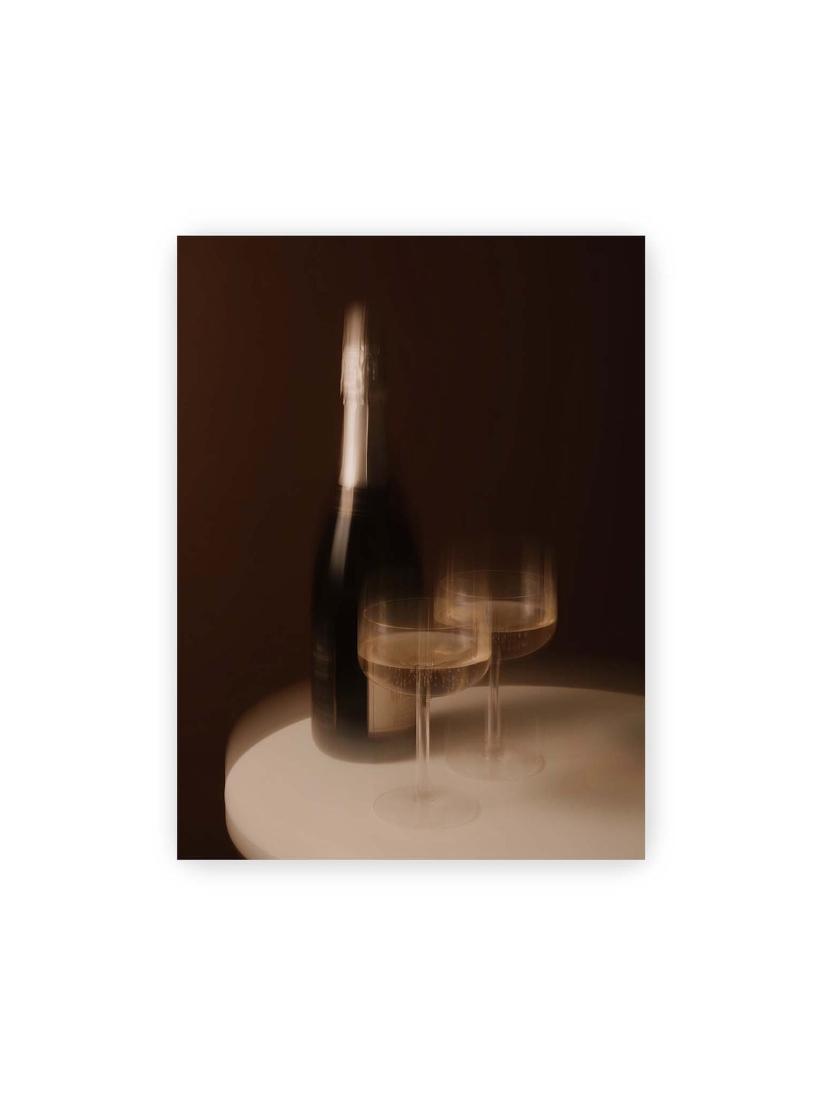 30x40 cm – Dunkle Flasche und zwei gefüllte Weingläser mit warmen Lichtreflexen auf einem runden hellen Tisch.