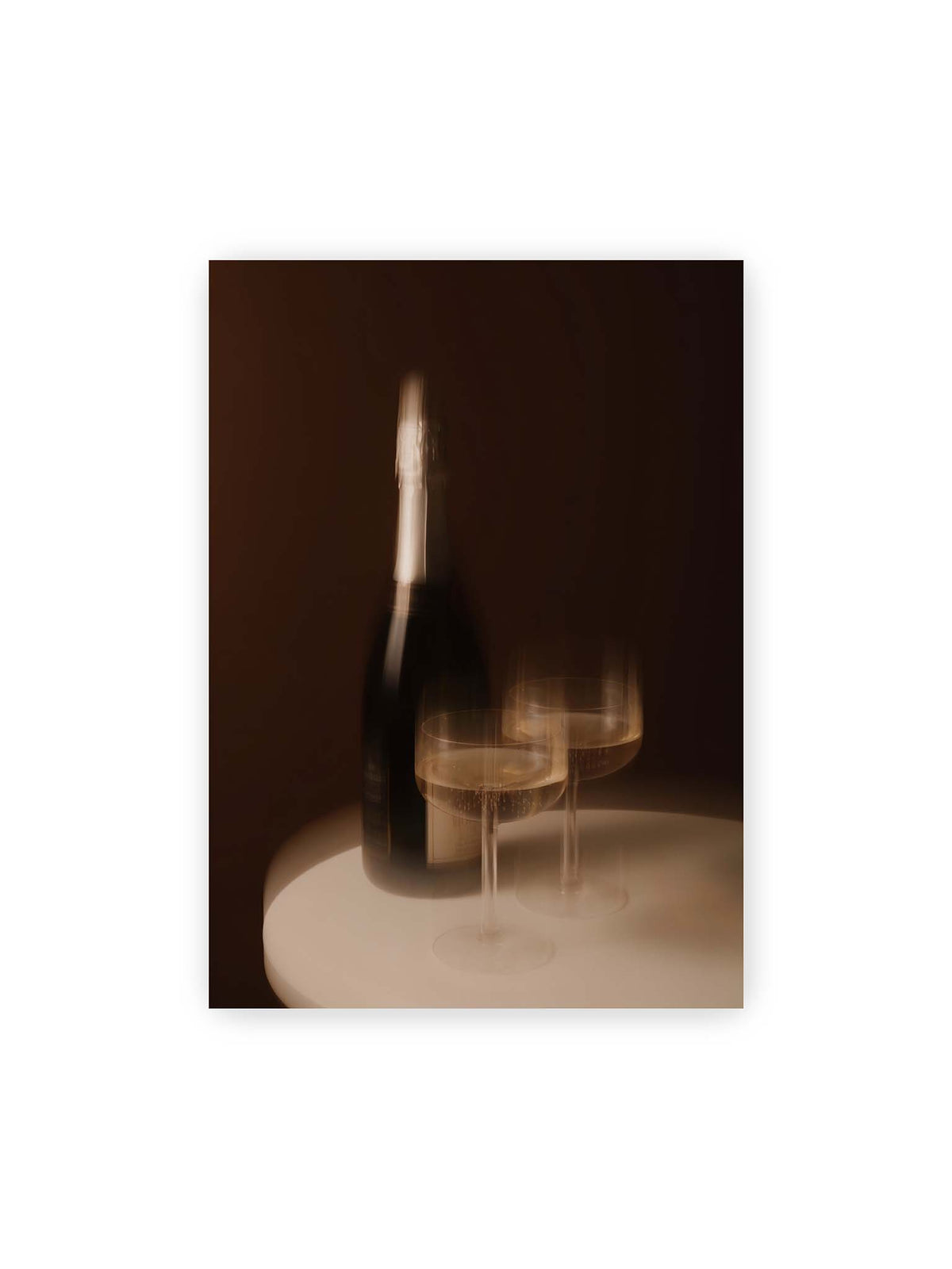 50x70 cm – Dunkle Flasche und zwei gefüllte Weingläser mit warmen Lichtreflexen auf einem runden hellen Tisch.