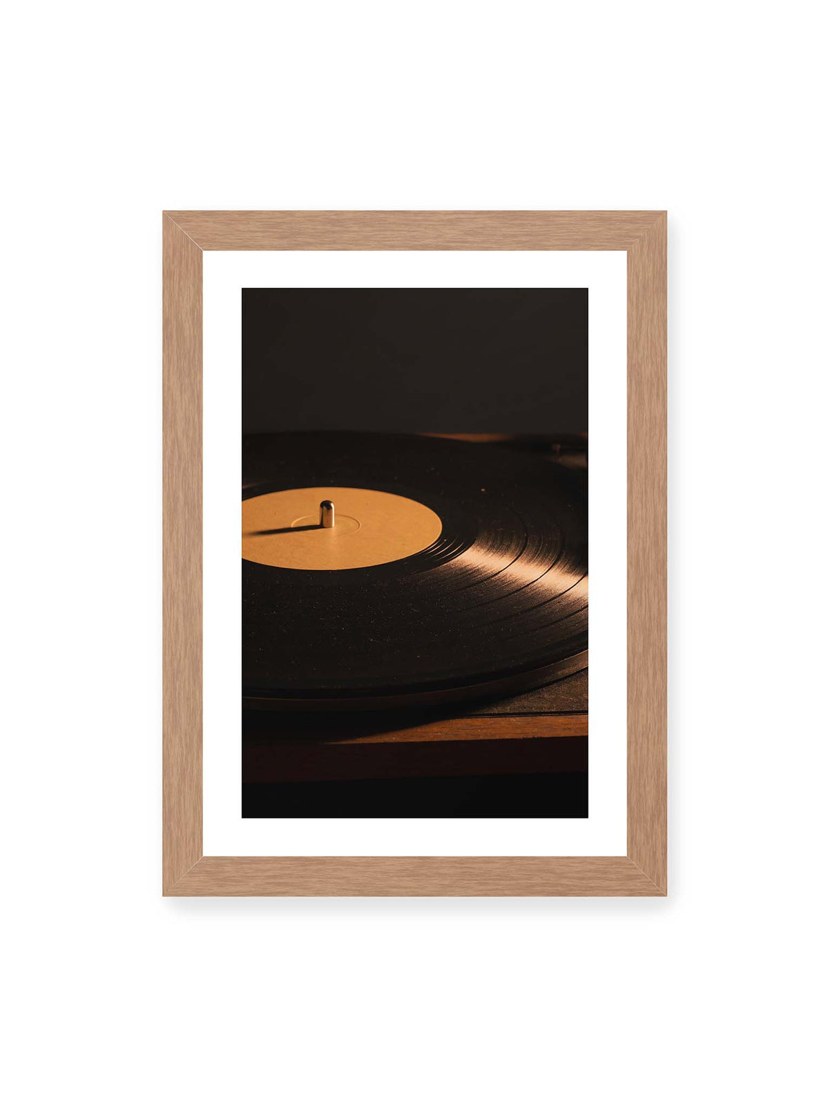 21x30 cm, weißer Galerie-Rand, Eichenrahmen – Schallplatte auf einem Plattenspieler mit goldenem Lichtreflex auf Label und Rillen.