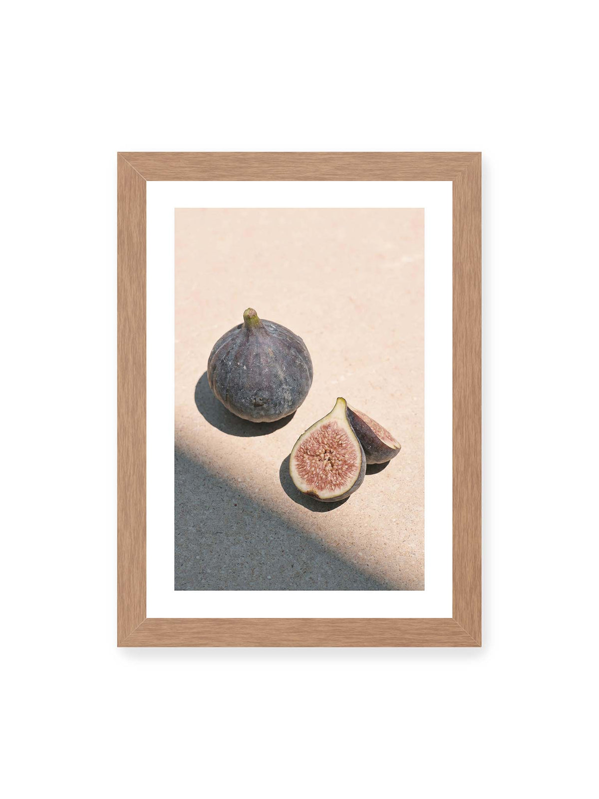 21x30 cm, weißer Galerie-Rand, Eichenrahmen – Ganze und halbierte Feigen auf heller Fläche im direkten Licht mit klaren Schatten.
