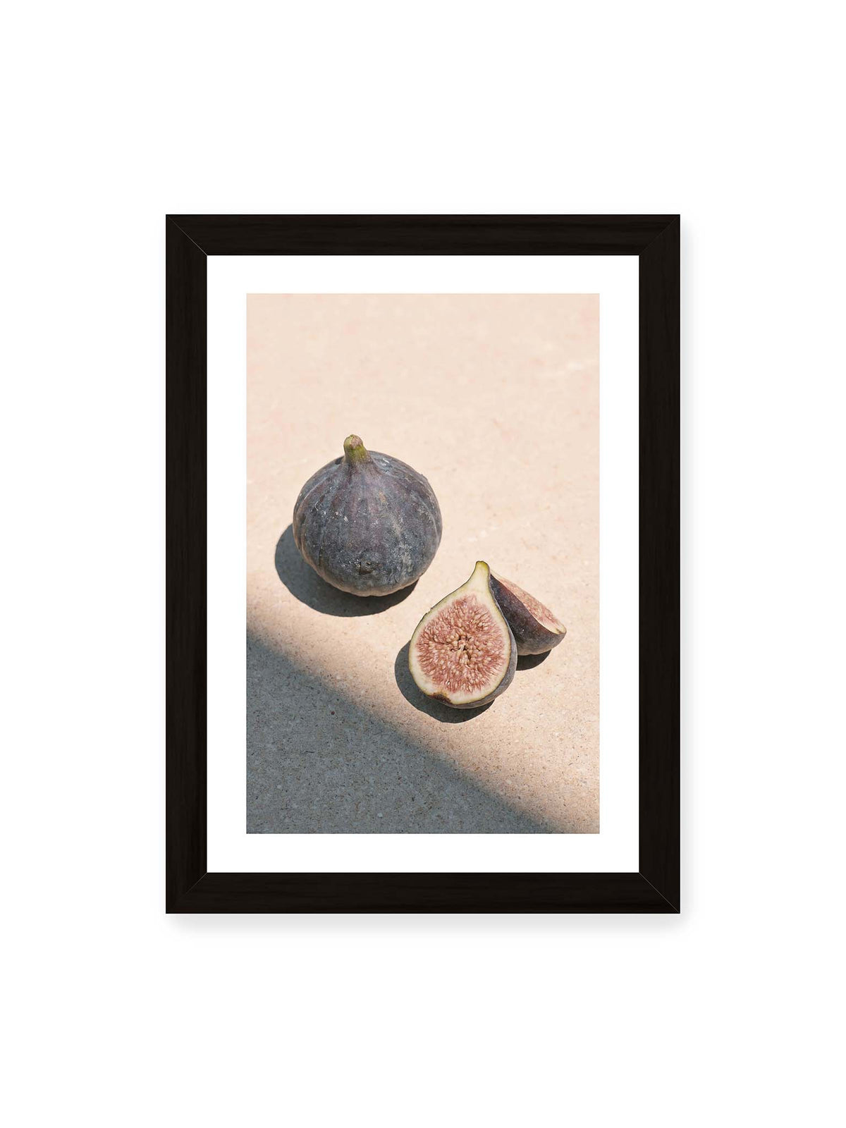 21x30 cm, weißer Galerie-Rand, schwarzer Rahmen – Ganze und halbierte Feigen auf heller Fläche im direkten Licht mit klaren Schatten.