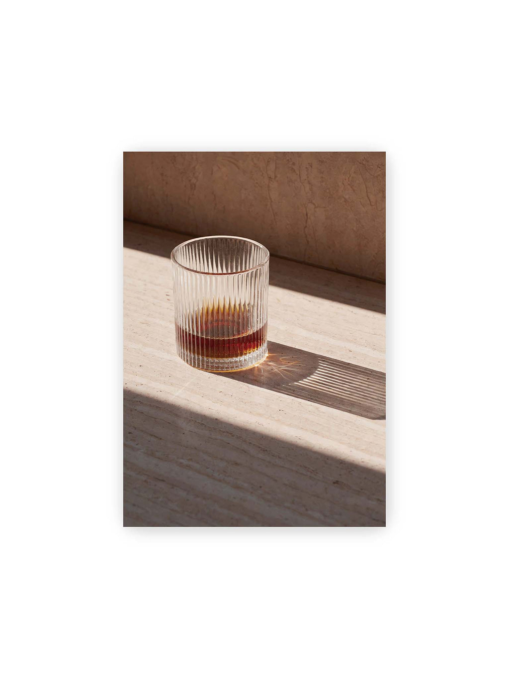 21x30 cm – Geripptes Glas mit bernsteinfarbener Flüssigkeit auf heller Steinfläche im direkten Licht.