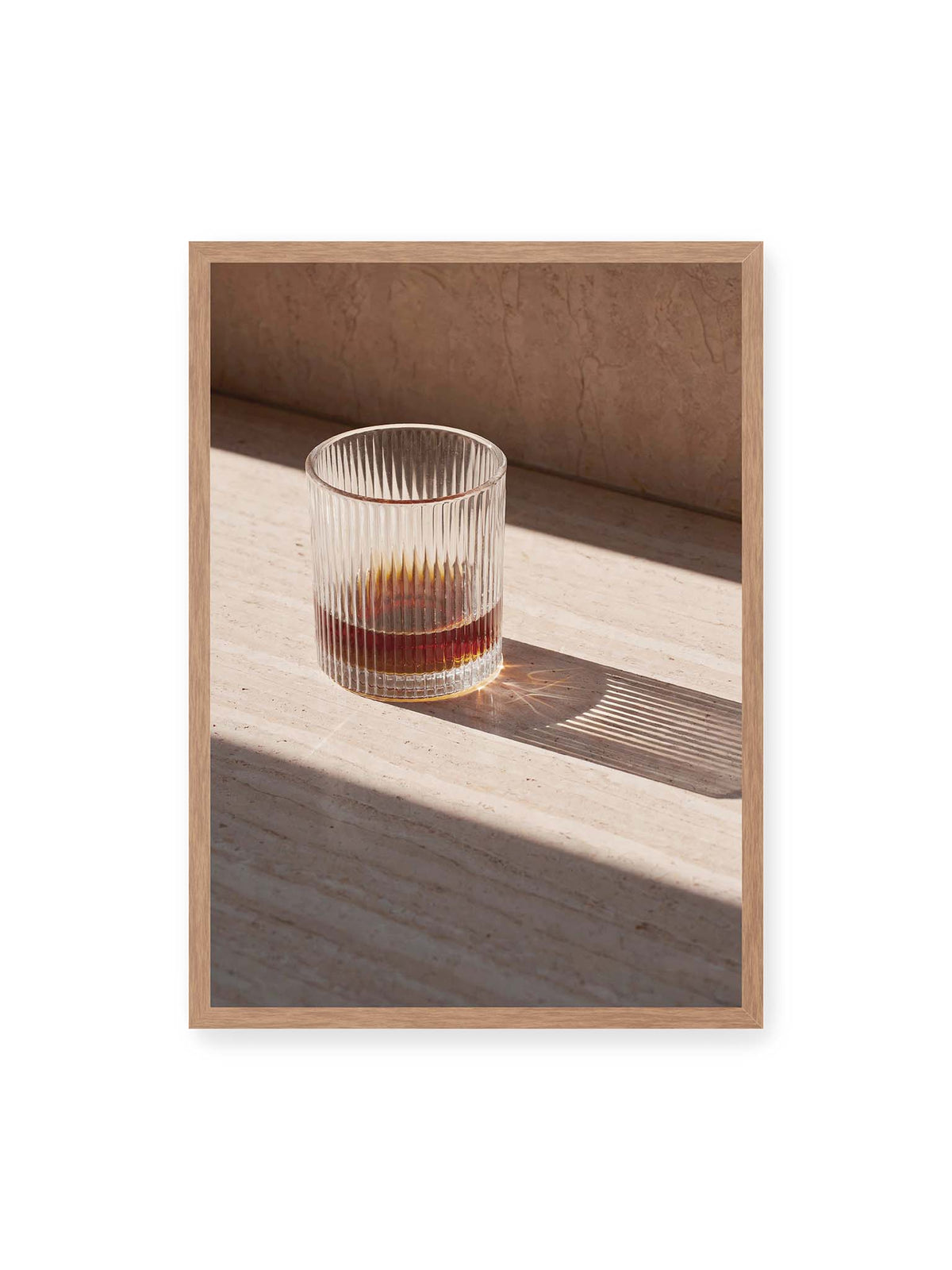 50x70 cm, Eichenrahmen – Geripptes Glas mit bernsteinfarbener Flüssigkeit auf heller Steinfläche im direkten Licht.