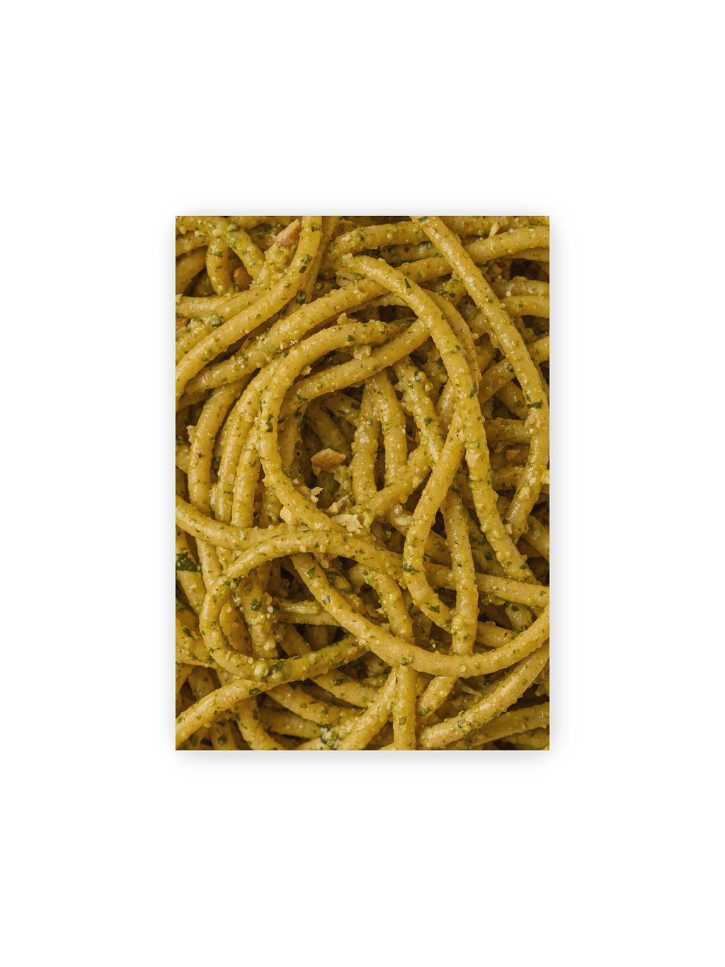 21x30 cm – Eng verschlungene Pasta mit grünlich gelber Sauce und feinen Kräuterstücken in dichter Nahaufnahme.