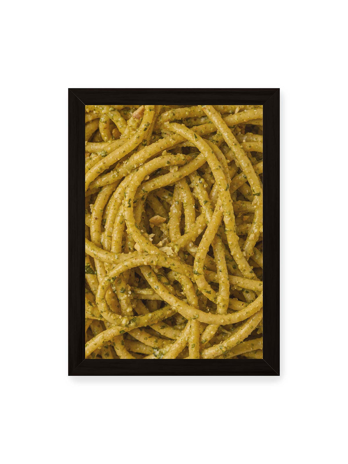 21x30 cm, schwarzer Rahmen – Eng verschlungene Pasta mit grünlich gelber Sauce und feinen Kräuterstücken in dichter Nahaufnahme.