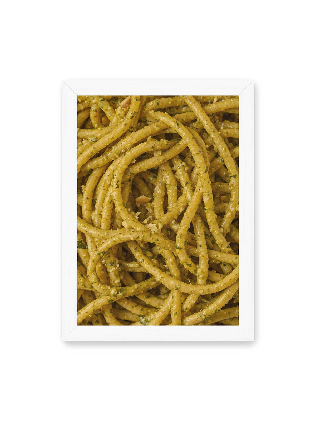 21x30 cm, weißer Rahmen – Eng verschlungene Pasta mit grünlich gelber Sauce und feinen Kräuterstücken in dichter Nahaufnahme.