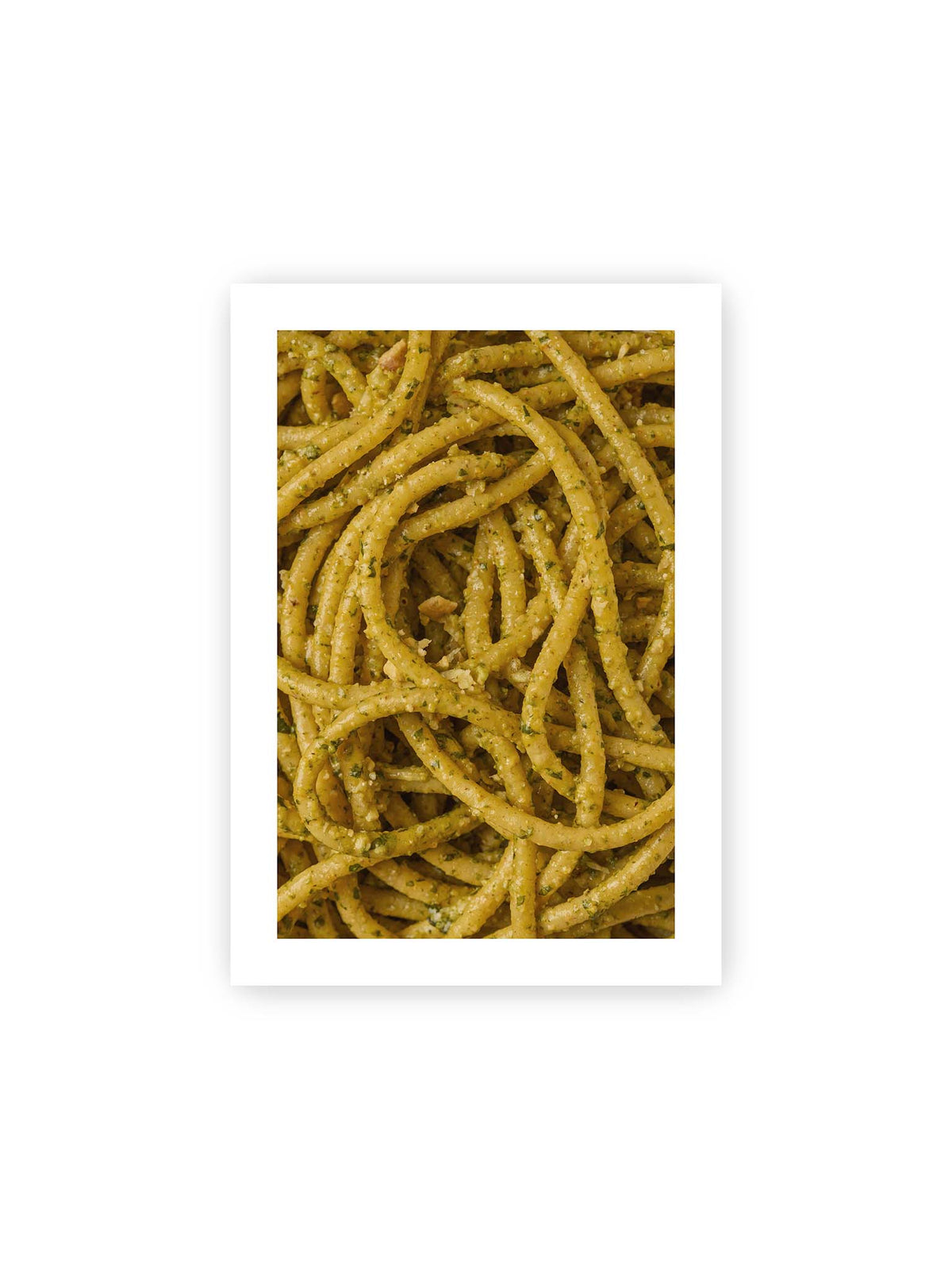 21x30 cm, weißer Galerie-Rand – Eng verschlungene Pasta mit grünlich gelber Sauce und feinen Kräuterstücken in dichter Nahaufnahme.