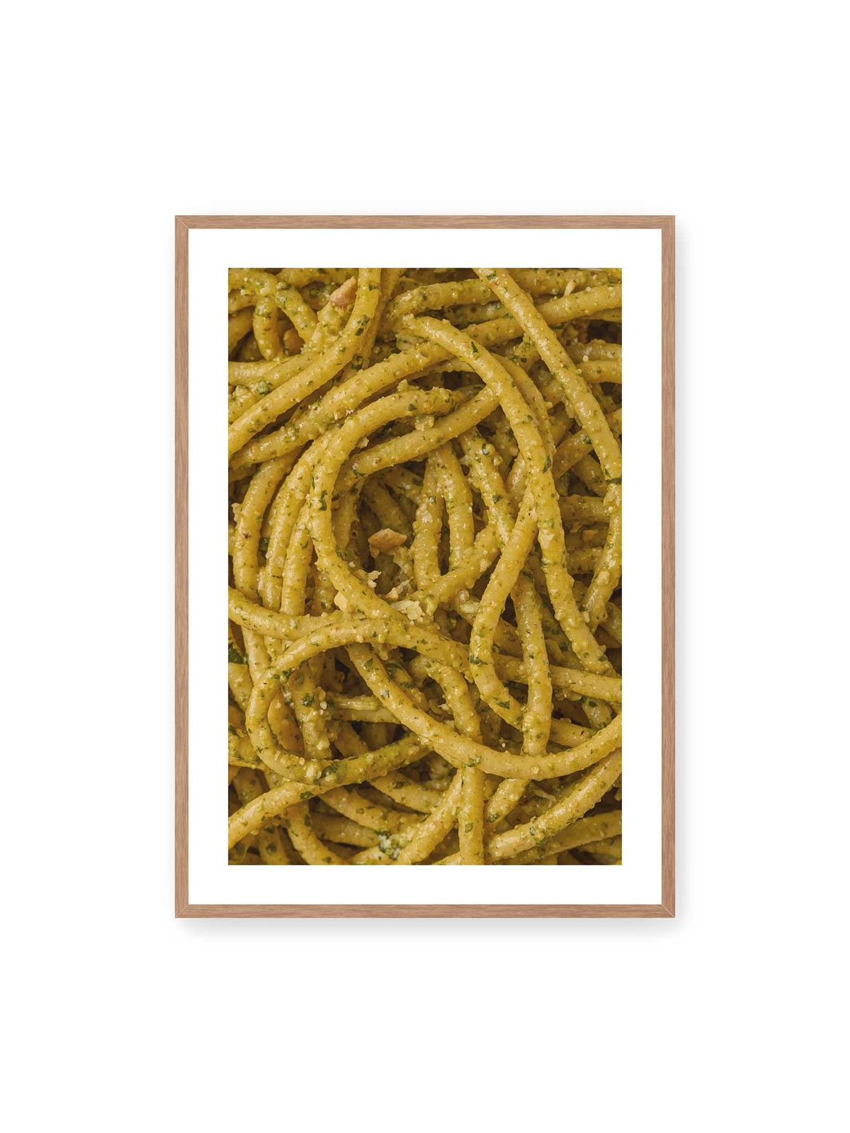70x100 cm, weißer Galerie-Rand, Eichenrahmen – Eng verschlungene Pasta mit grünlich gelber Sauce und feinen Kräuterstücken in dichter Nahaufnahme.