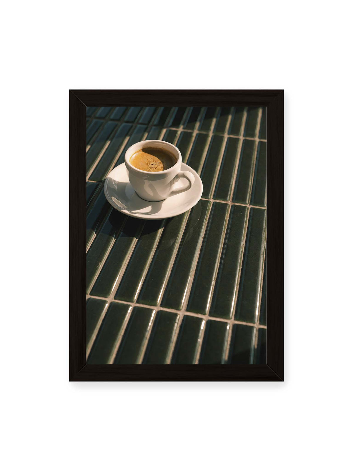 21x30 cm, schwarzer Rahmen – Weiße Espressotasse auf dunkelgrünen Fliesen im direkten Licht mit geometrischen Schatten.