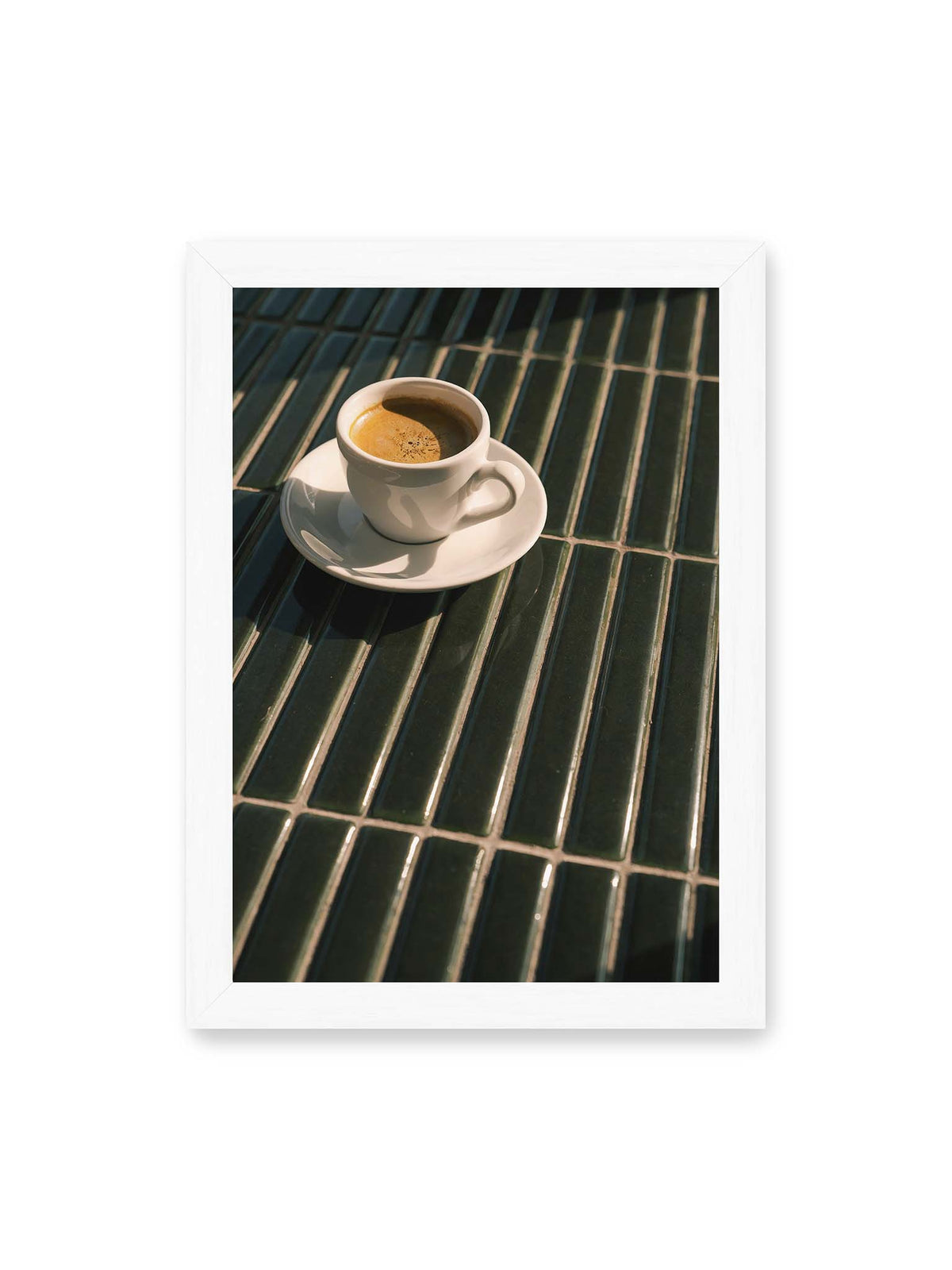 21x30 cm, weißer Rahmen – Weiße Espressotasse auf dunkelgrünen Fliesen im direkten Licht mit geometrischen Schatten.