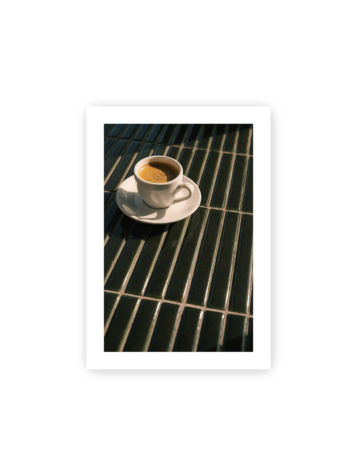 21x30 cm, weißer Galerie-Rand – Weiße Espressotasse auf dunkelgrünen Fliesen im direkten Licht mit geometrischen Schatten.