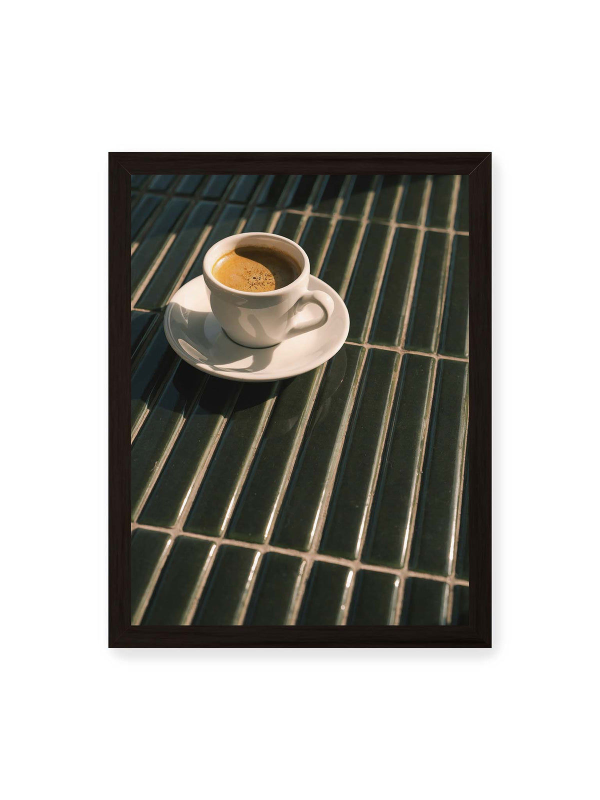30x40 cm, schwarzer Rahmen – Weiße Espressotasse auf dunkelgrünen Fliesen im direkten Licht mit geometrischen Schatten.