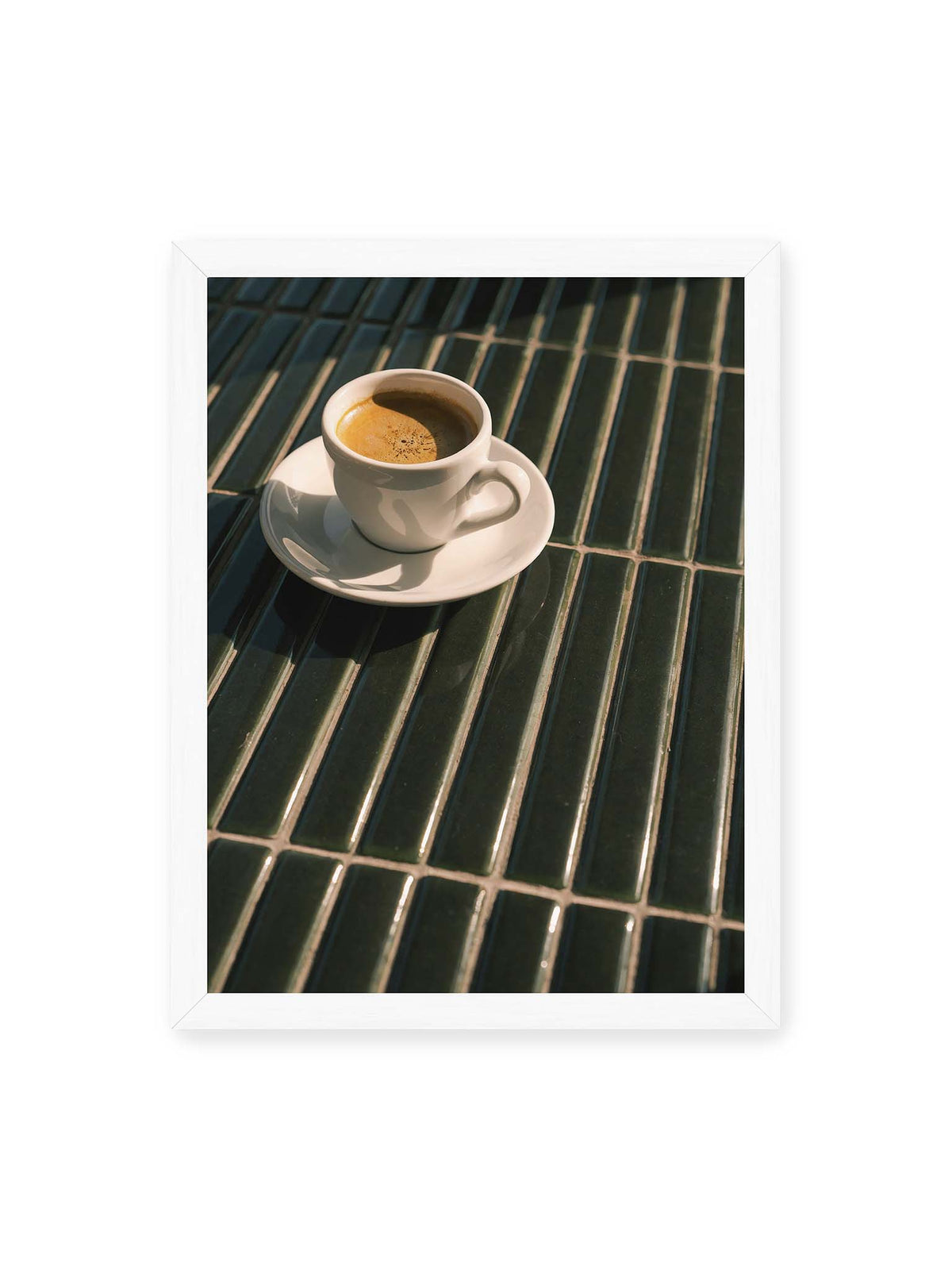 30x40 cm, weißer Rahmen – Weiße Espressotasse auf dunkelgrünen Fliesen im direkten Licht mit geometrischen Schatten.