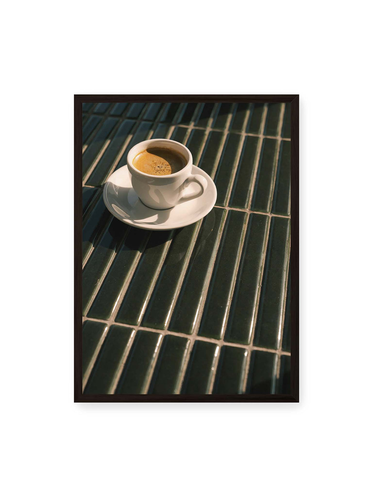 50x70 cm, schwarzer Rahmen – Weiße Espressotasse auf dunkelgrünen Fliesen im direkten Licht mit geometrischen Schatten.