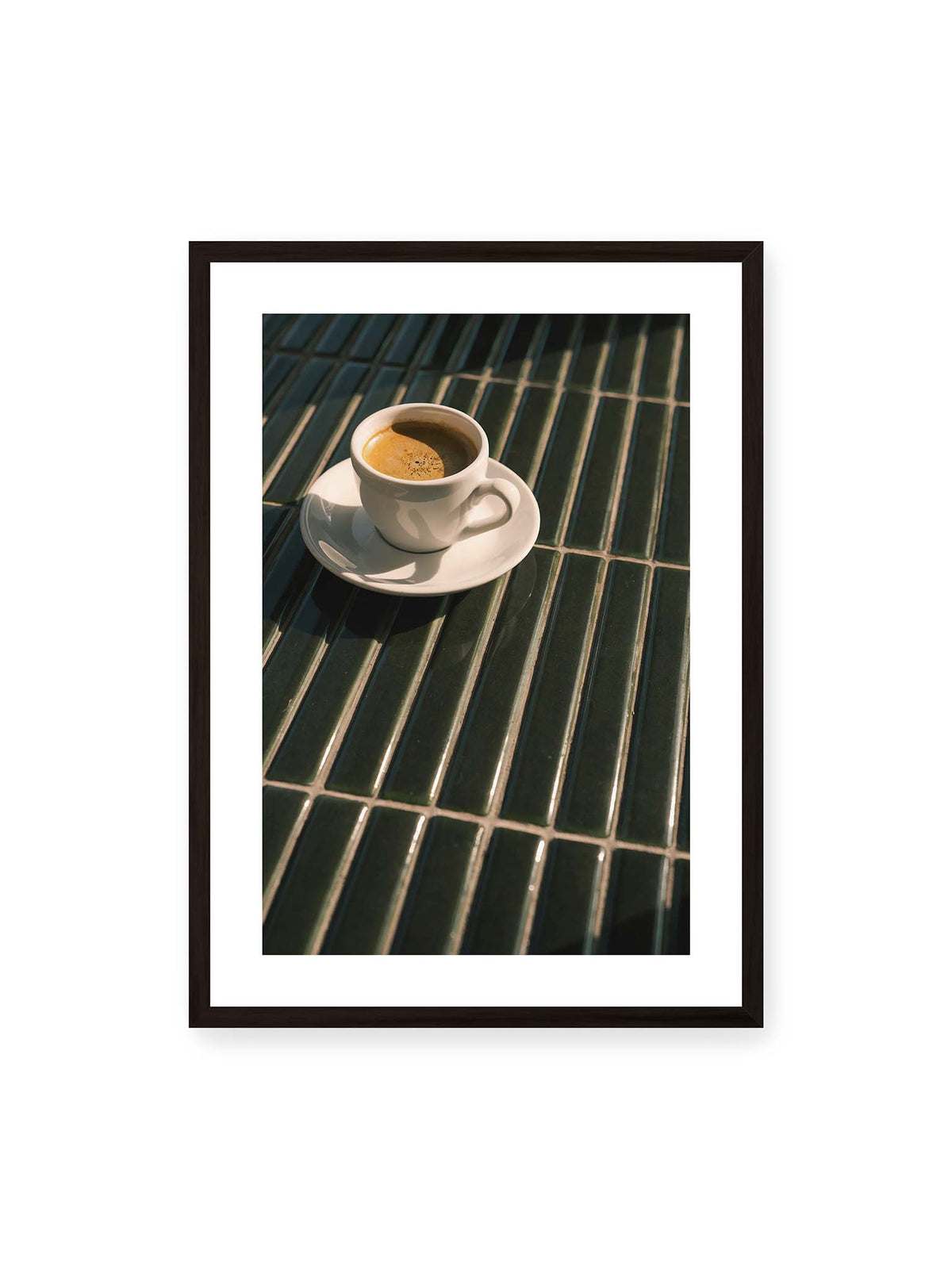 50x70 cm, weißer Galerie-Rand, schwarzer Rahmen – Weiße Espressotasse auf dunkelgrünen Fliesen im direkten Licht mit geometrischen Schatten.