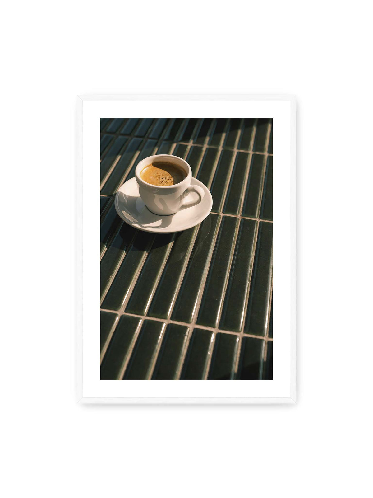 70x100 cm, weißer Galerie-Rand, weißer Rahmen – Weiße Espressotasse auf dunkelgrünen Fliesen im direkten Licht mit geometrischen Schatten.