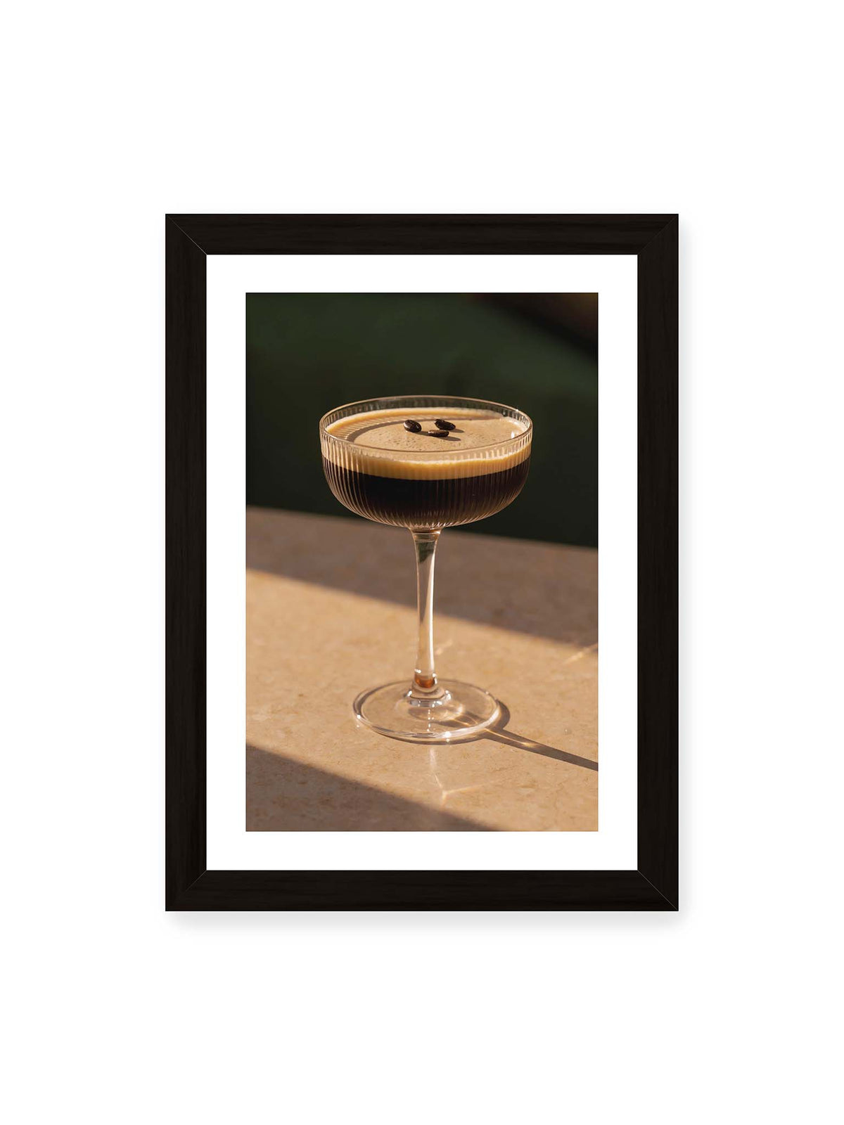 21x30 cm, weißer Galerie-Rand, schwarzer Rahmen – Espresso Martini im geriffelten Coupé-Glas mit heller Crema und drei Kaffeebohnen im warmen Licht.
