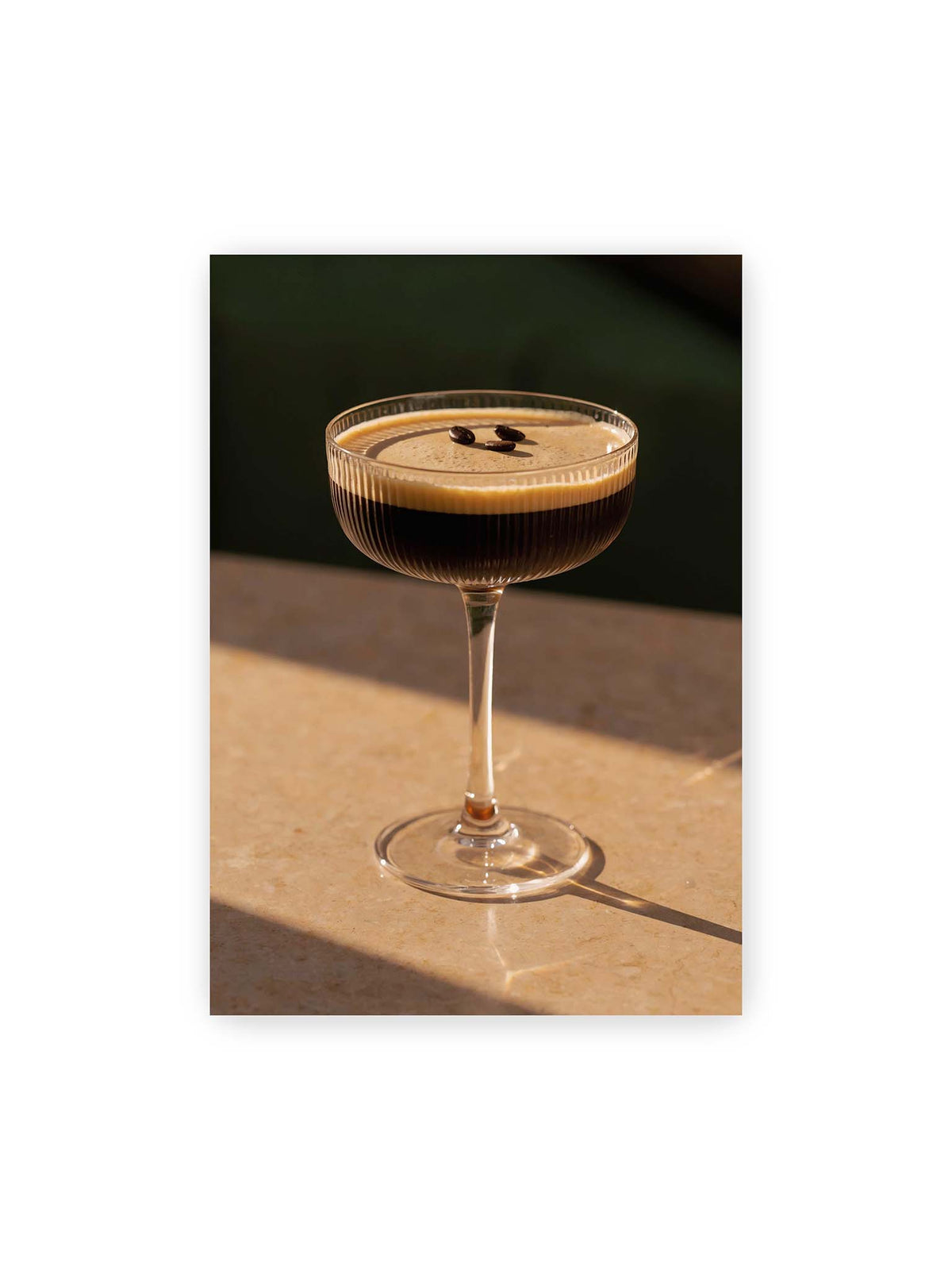 70x100 cm – Espresso Martini im geriffelten Coupé-Glas mit heller Crema und drei Kaffeebohnen im warmen Licht.