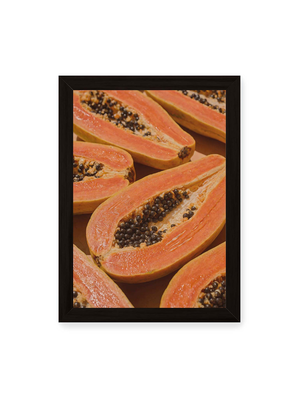21x30 cm, schwarzer Rahmen – Aufgeschnittene Papayas mit orangefarbenem Fruchtfleisch und zahlreichen dunklen Kernen in enger Nahaufnahme.