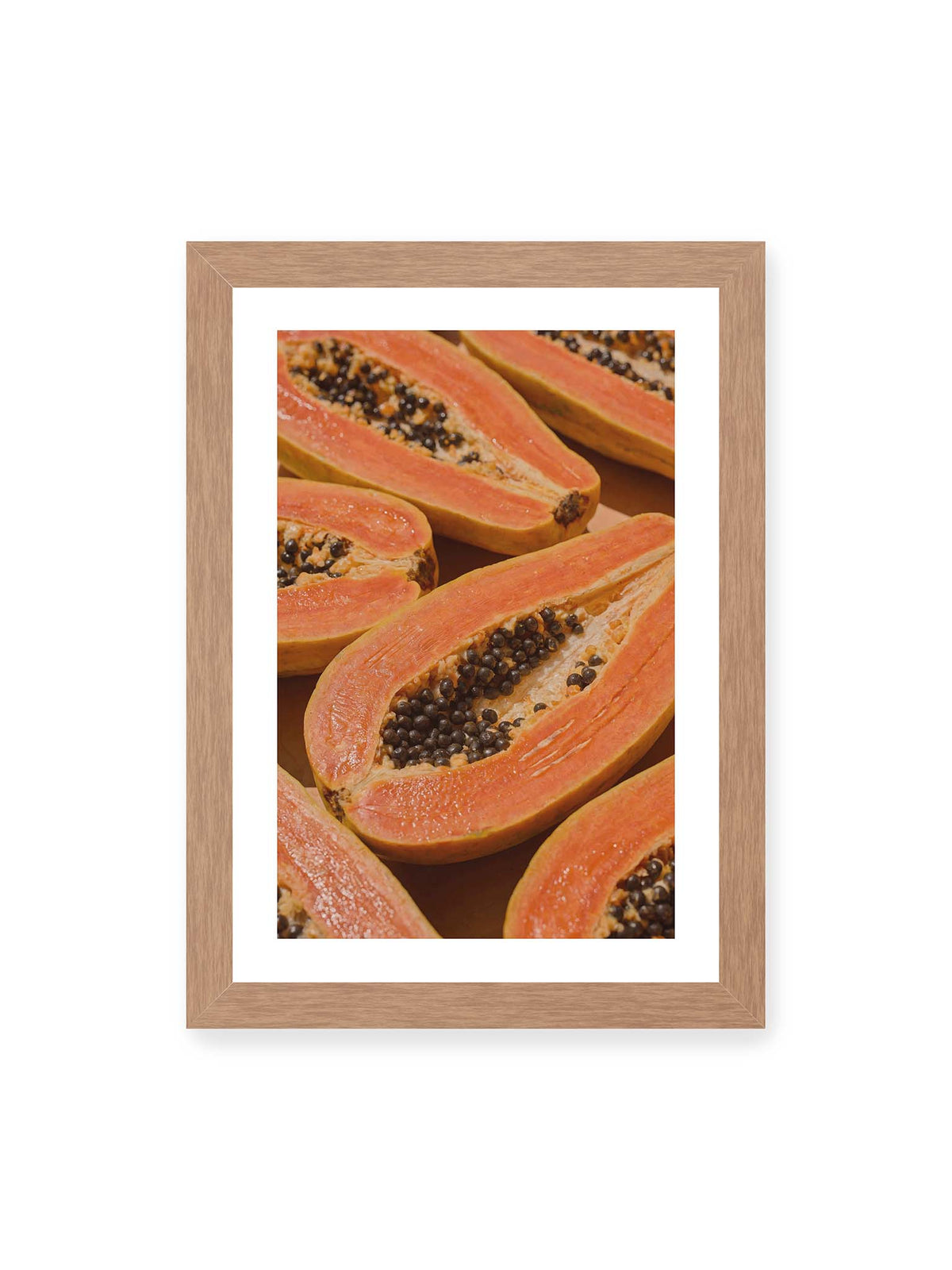 21x30 cm, weißer Galerie-Rand, Eichenrahmen – Aufgeschnittene Papayas mit orangefarbenem Fruchtfleisch und zahlreichen dunklen Kernen in enger Nahaufnahme.