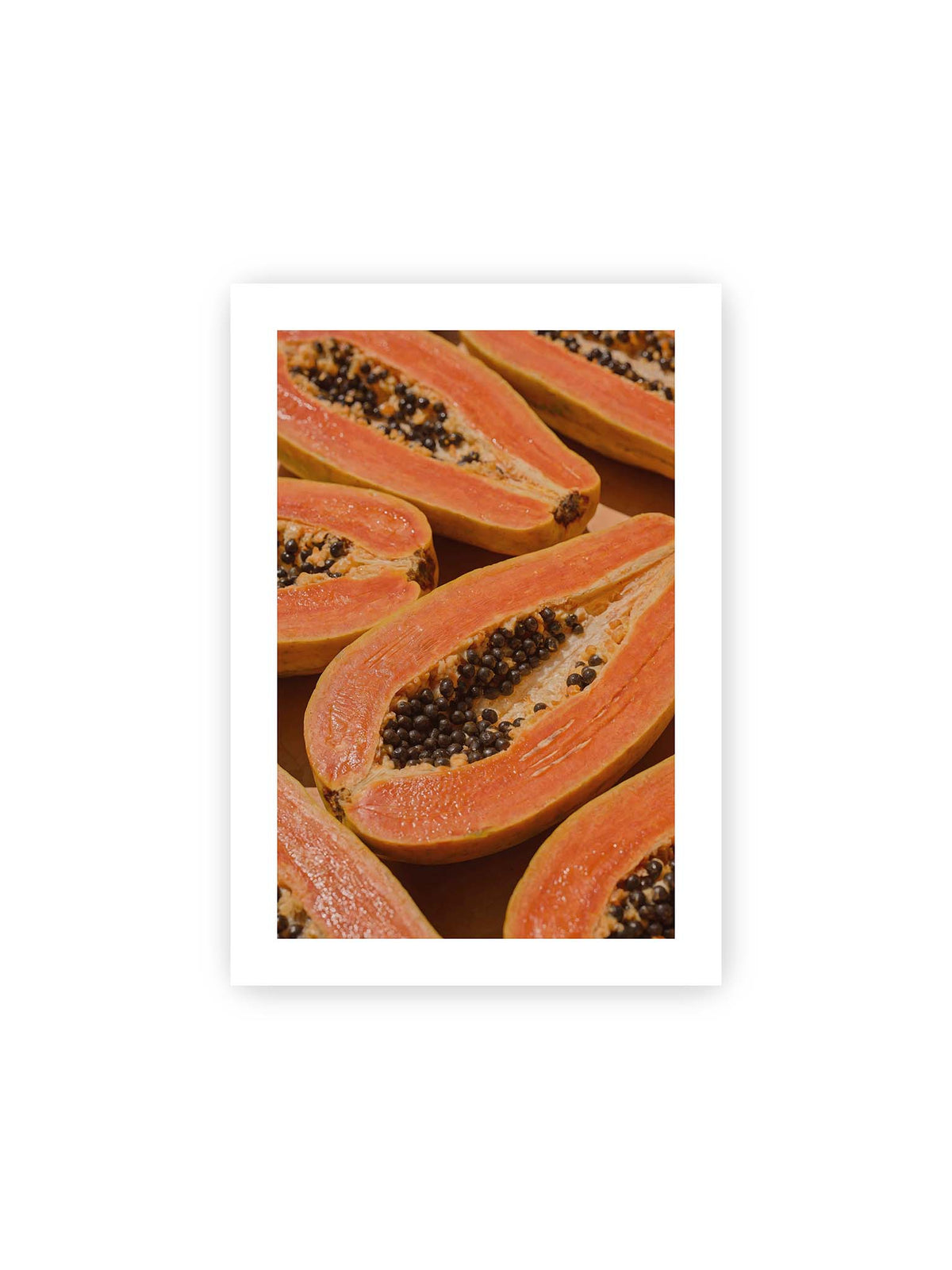 21x30 cm, weißer Galerie-Rand – Aufgeschnittene Papayas mit orangefarbenem Fruchtfleisch und zahlreichen dunklen Kernen in enger Nahaufnahme.