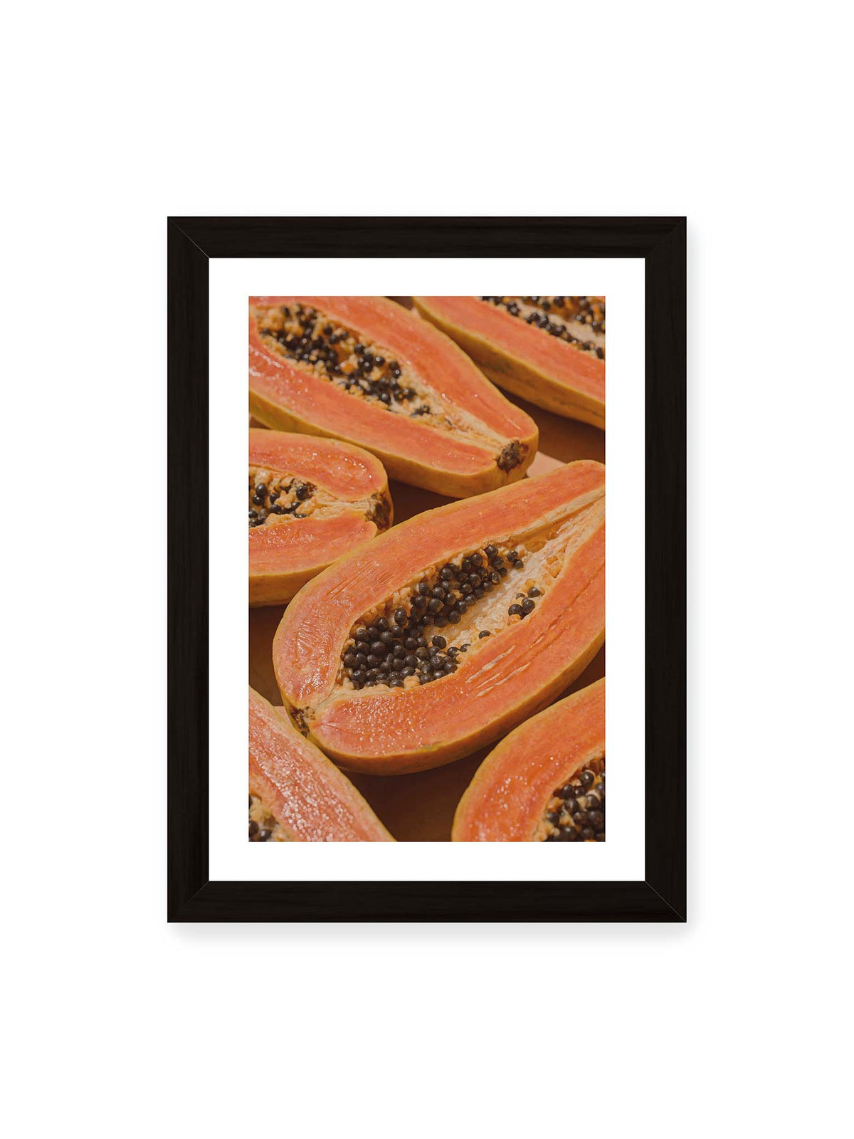 21x30 cm, weißer Galerie-Rand, schwarzer Rahmen – Aufgeschnittene Papayas mit orangefarbenem Fruchtfleisch und zahlreichen dunklen Kernen in enger Nahaufnahme.