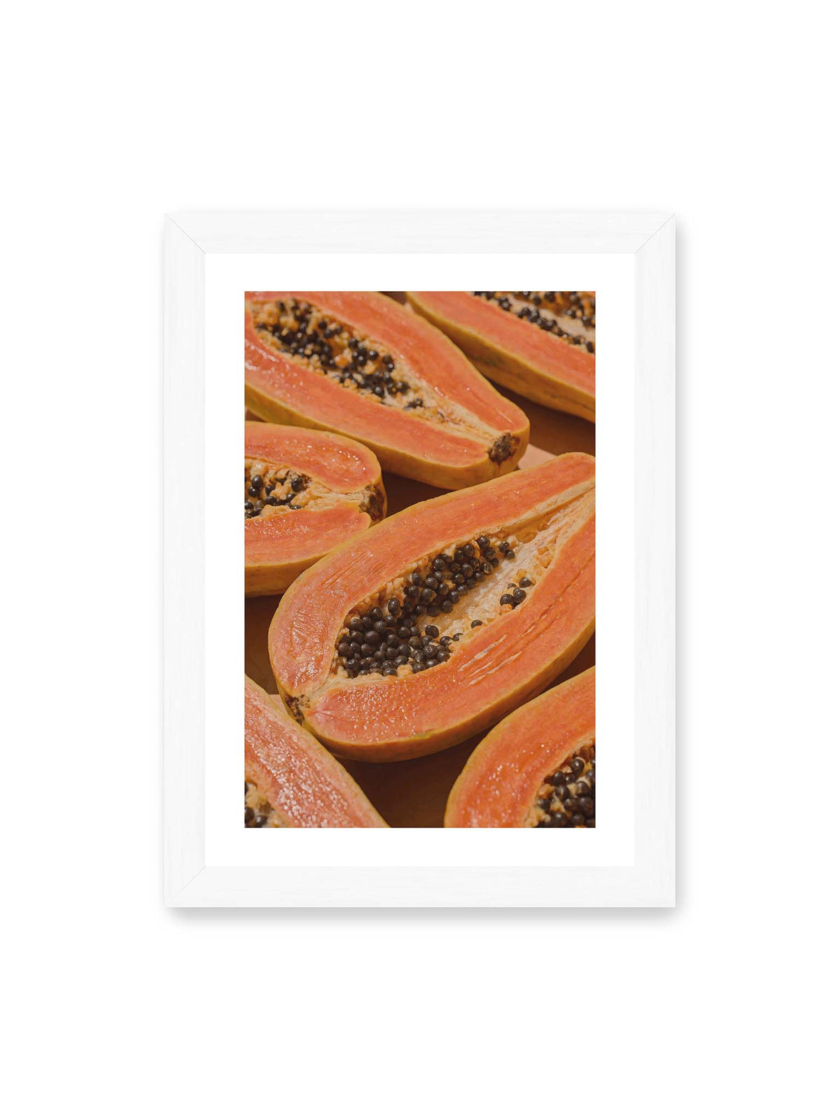 21x30 cm, weißer Galerie-Rand, weißer Rahmen – Aufgeschnittene Papayas mit orangefarbenem Fruchtfleisch und zahlreichen dunklen Kernen in enger Nahaufnahme.