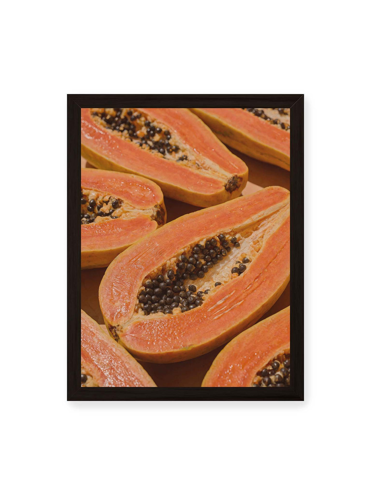 30x40 cm, schwarzer Rahmen – Aufgeschnittene Papayas mit orangefarbenem Fruchtfleisch und zahlreichen dunklen Kernen in enger Nahaufnahme.