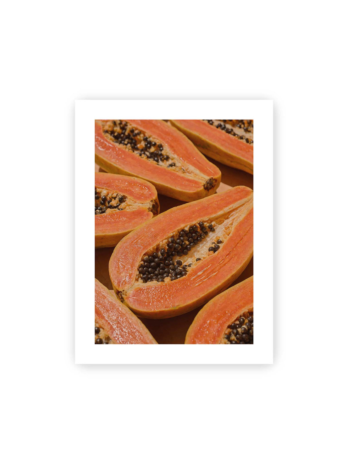 30x40 cm, weißer Galerie-Rand – Aufgeschnittene Papayas mit orangefarbenem Fruchtfleisch und zahlreichen dunklen Kernen in enger Nahaufnahme.