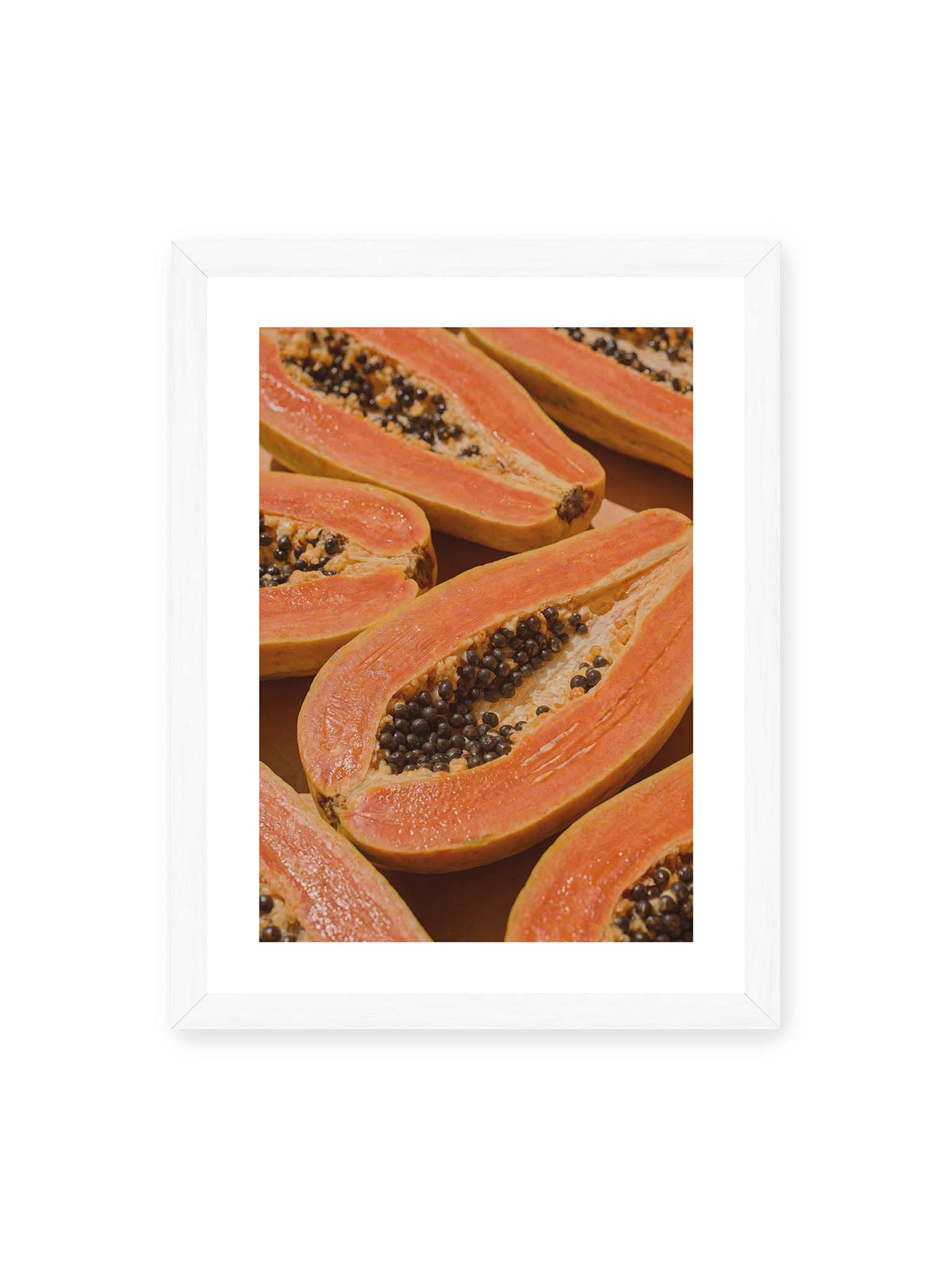 30x40 cm, weißer Galerie-Rand, weißer Rahmen – Aufgeschnittene Papayas mit orangefarbenem Fruchtfleisch und zahlreichen dunklen Kernen in enger Nahaufnahme.