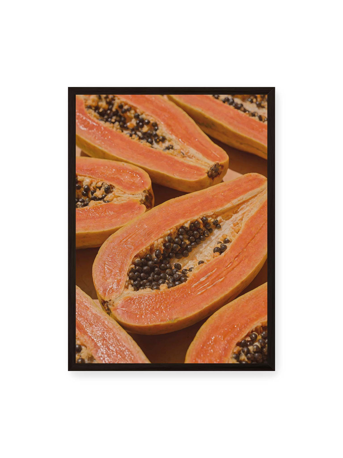 50x70 cm, schwarzer Rahmen – Aufgeschnittene Papayas mit orangefarbenem Fruchtfleisch und zahlreichen dunklen Kernen in enger Nahaufnahme.