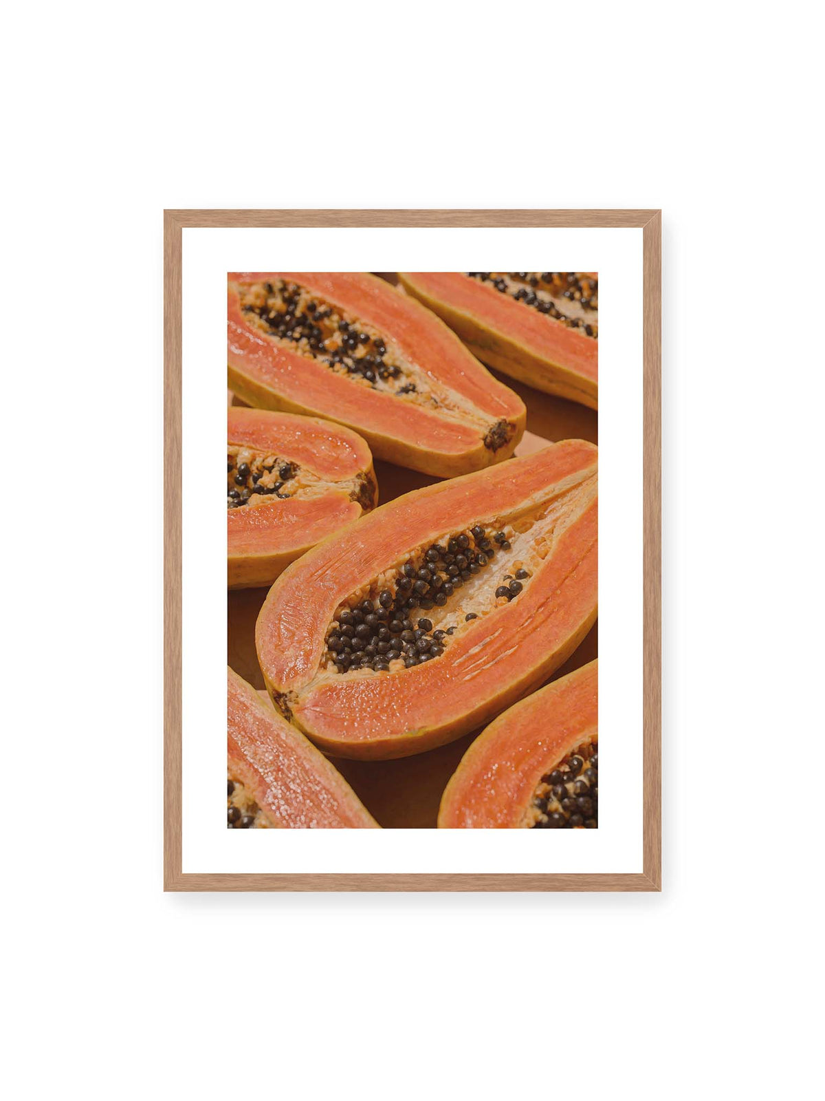 50x70 cm, weißer Galerie-Rand, Eichenrahmen – Aufgeschnittene Papayas mit orangefarbenem Fruchtfleisch und zahlreichen dunklen Kernen in enger Nahaufnahme.