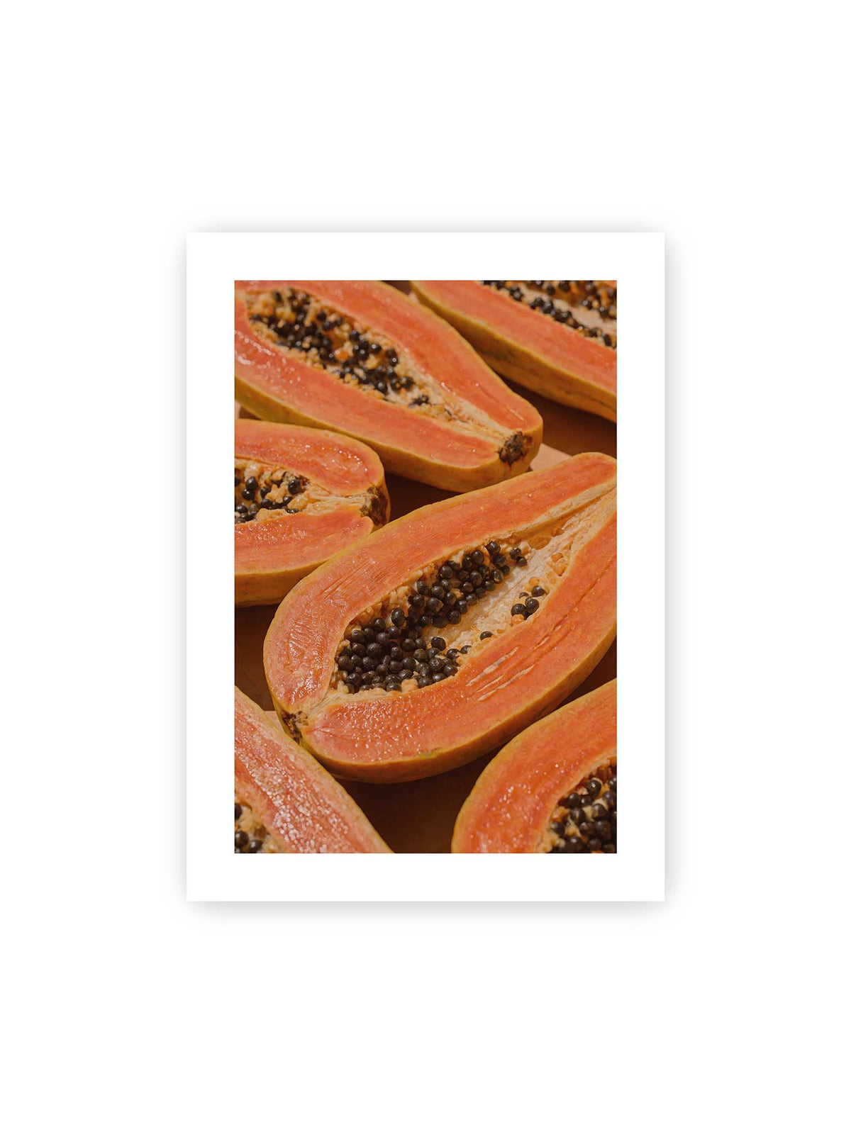 50x70 cm, weißer Galerie-Rand – Aufgeschnittene Papayas mit orangefarbenem Fruchtfleisch und zahlreichen dunklen Kernen in enger Nahaufnahme.