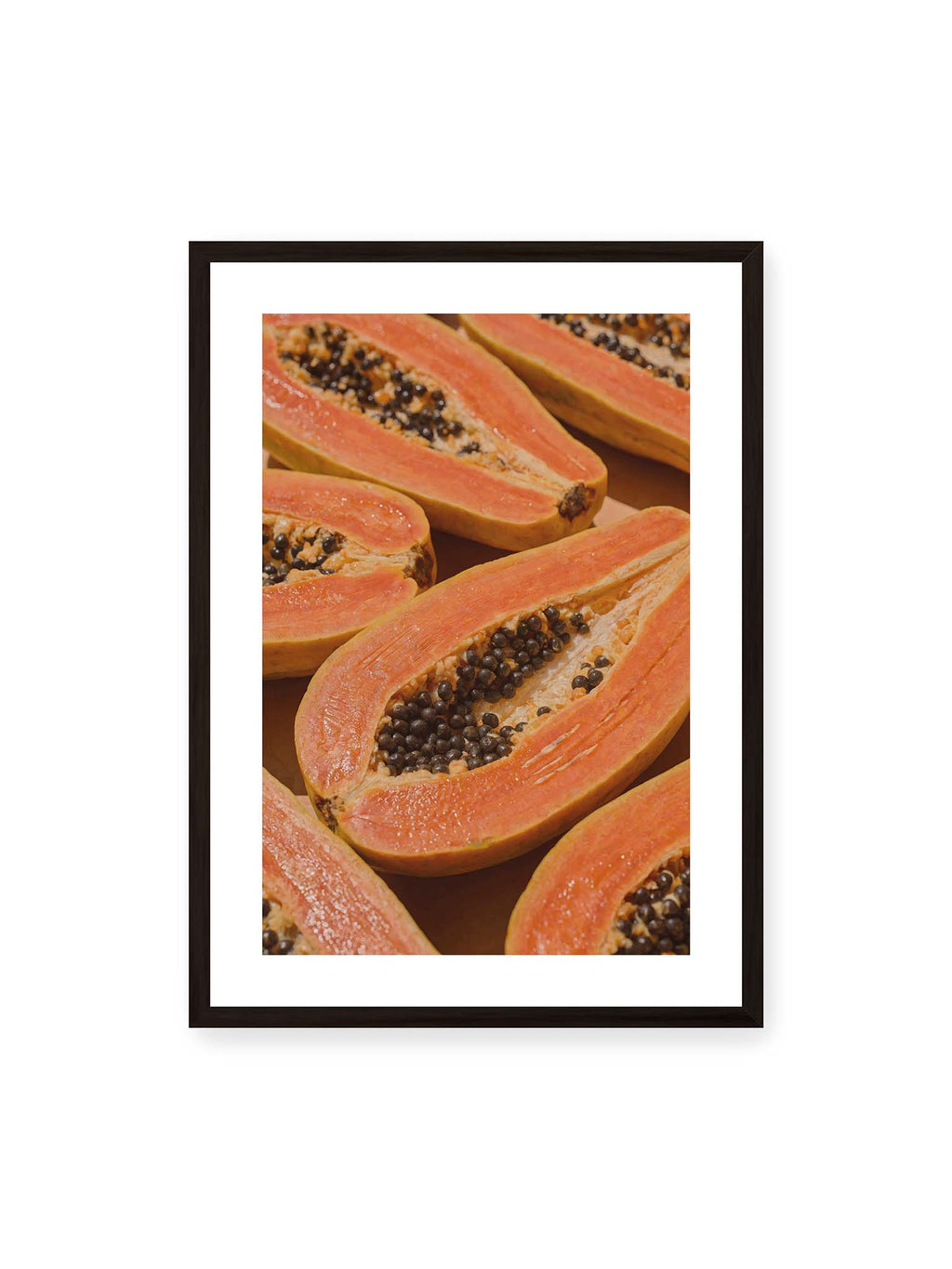 50x70 cm, weißer Galerie-Rand, schwarzer Rahmen – Aufgeschnittene Papayas mit orangefarbenem Fruchtfleisch und zahlreichen dunklen Kernen in enger Nahaufnahme.