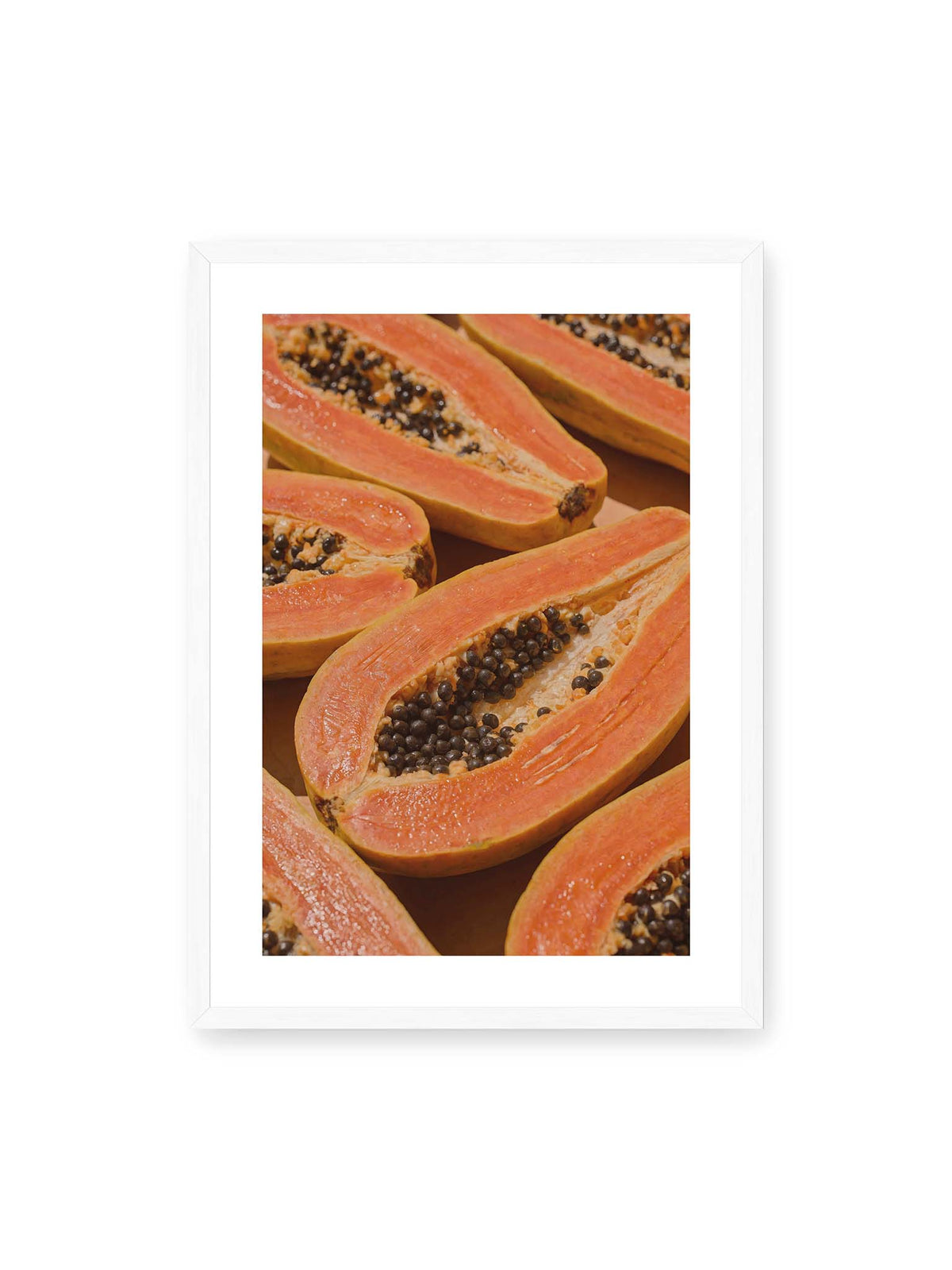 50x70 cm, weißer Galerie-Rand, weißer Rahmen – Aufgeschnittene Papayas mit orangefarbenem Fruchtfleisch und zahlreichen dunklen Kernen in enger Nahaufnahme.