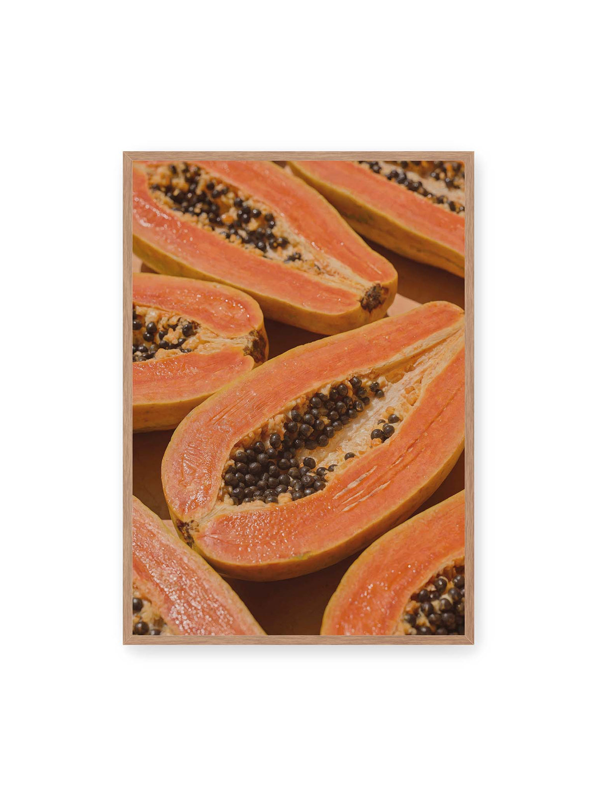 70x100 cm, Eichenrahmen – Aufgeschnittene Papayas mit orangefarbenem Fruchtfleisch und zahlreichen dunklen Kernen in enger Nahaufnahme.