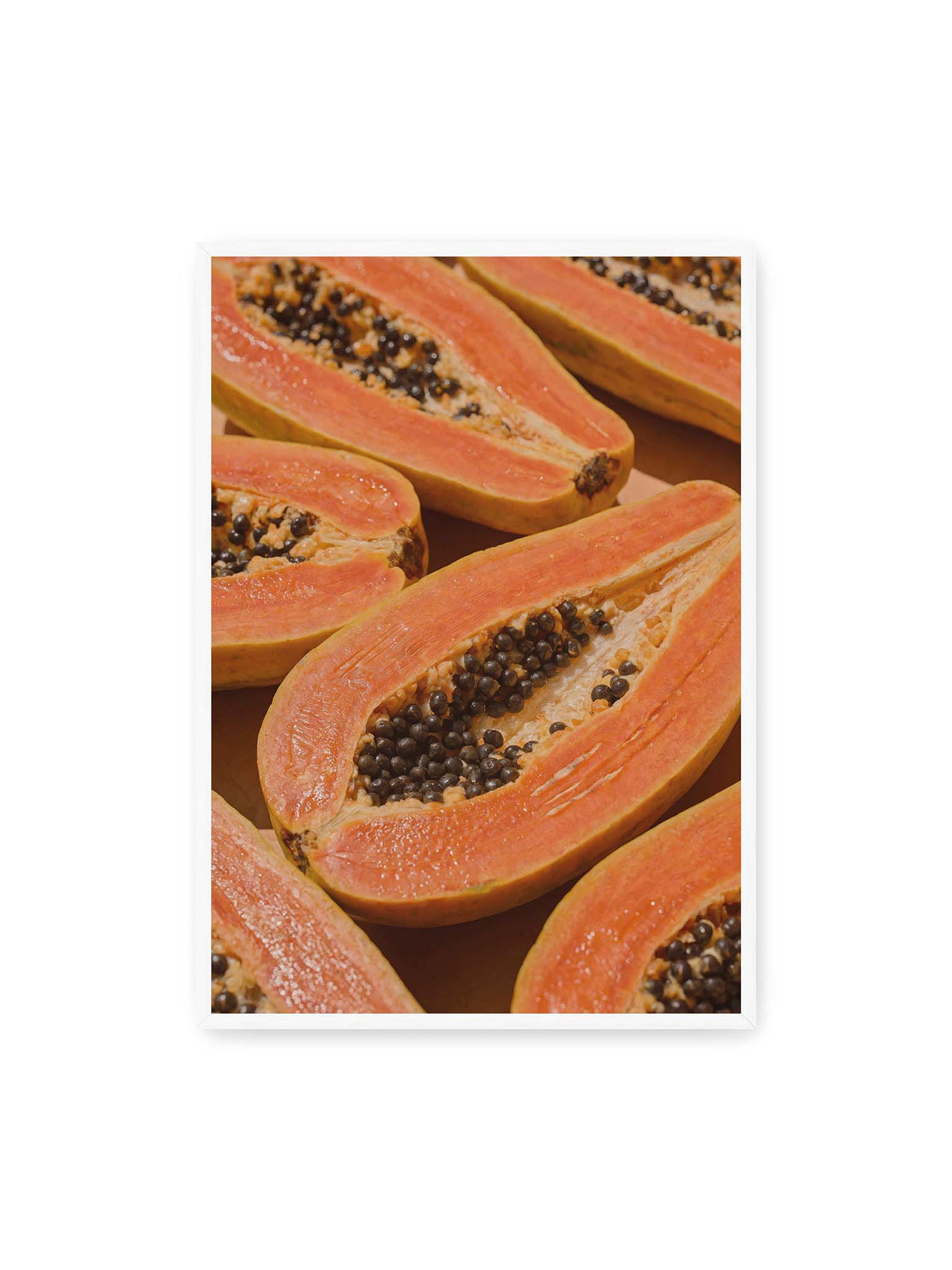 70x100 cm, weißer Rahmen – Aufgeschnittene Papayas mit orangefarbenem Fruchtfleisch und zahlreichen dunklen Kernen in enger Nahaufnahme.