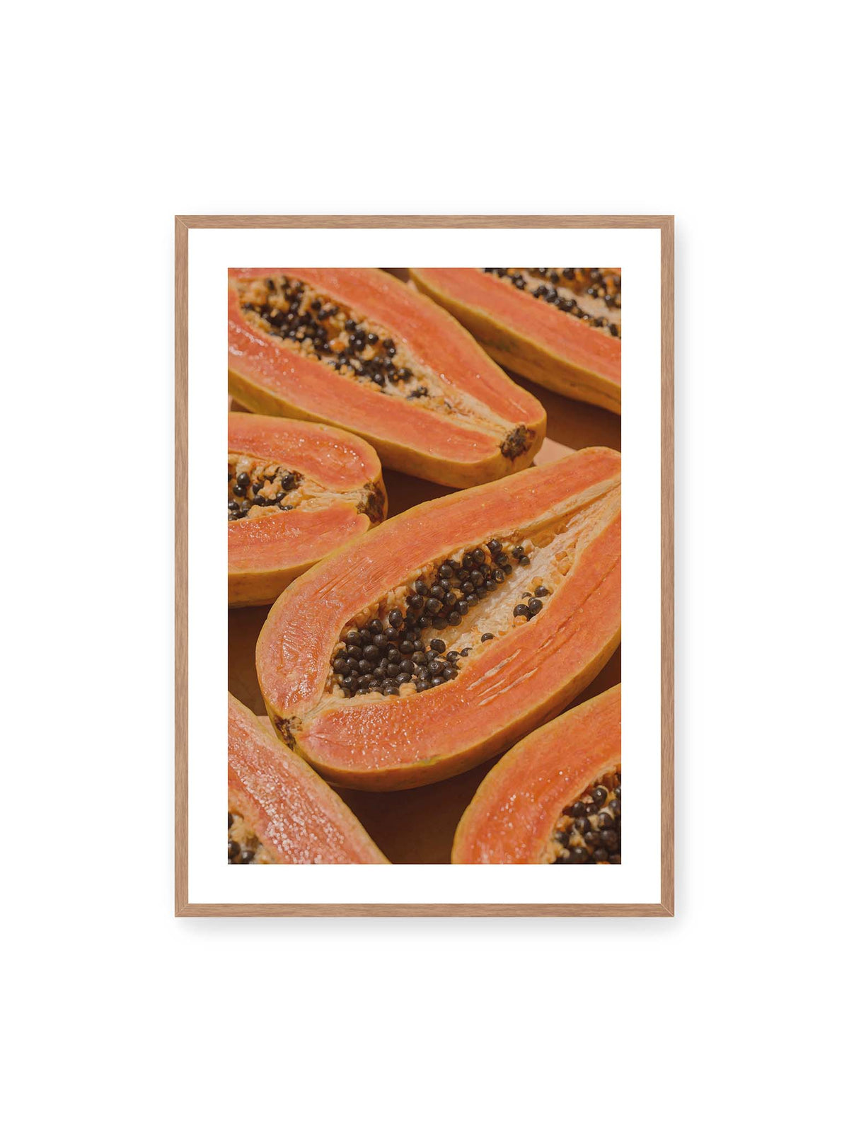 70x100 cm, weißer Galerie-Rand, Eichenrahmen – Aufgeschnittene Papayas mit orangefarbenem Fruchtfleisch und zahlreichen dunklen Kernen in enger Nahaufnahme.