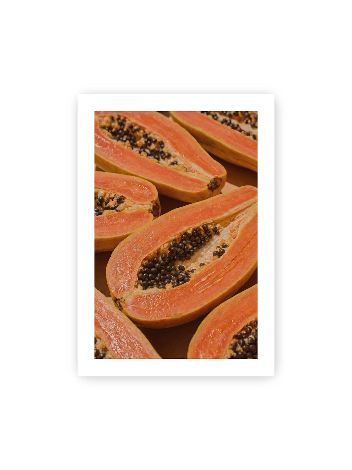 70x100 cm, weißer Galerie-Rand – Aufgeschnittene Papayas mit orangefarbenem Fruchtfleisch und zahlreichen dunklen Kernen in enger Nahaufnahme.