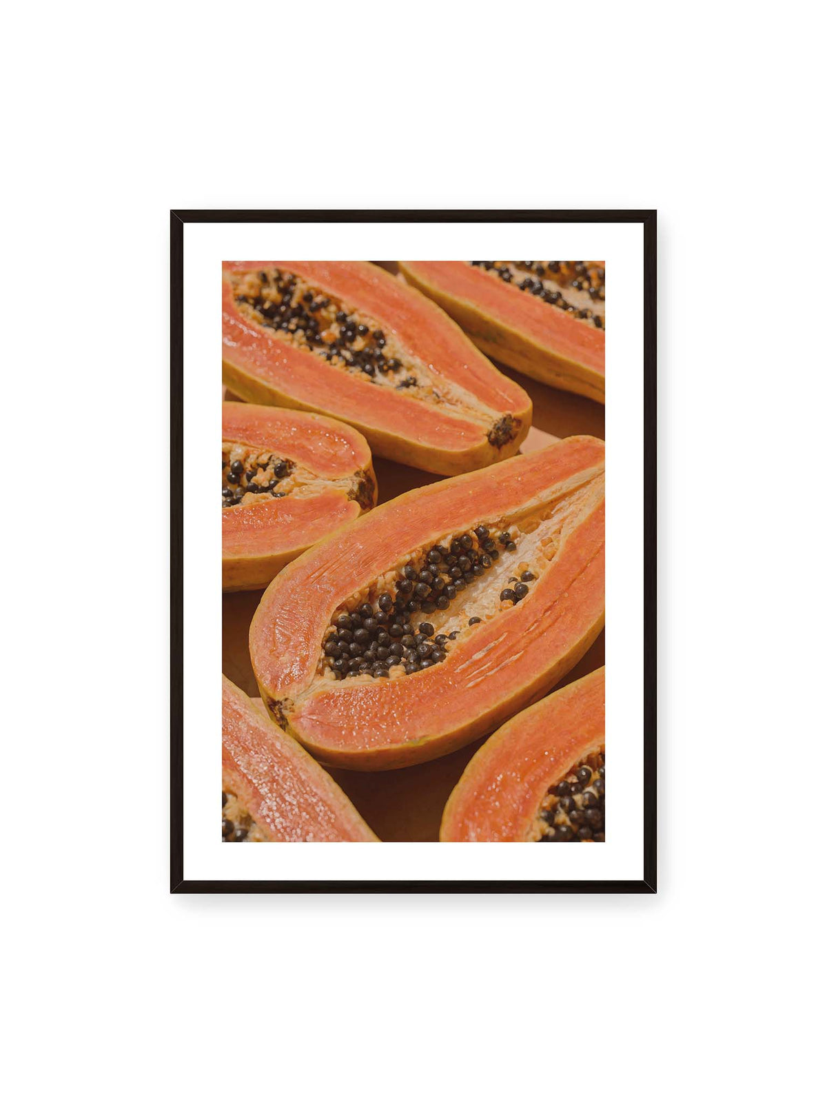 70x100 cm, weißer Galerie-Rand, schwarzer Rahmen – Aufgeschnittene Papayas mit orangefarbenem Fruchtfleisch und zahlreichen dunklen Kernen in enger Nahaufnahme.