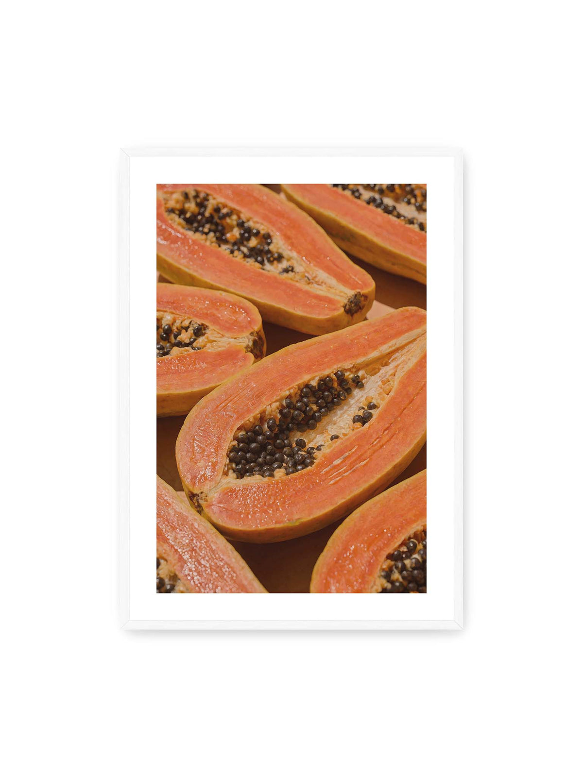 70x100 cm, weißer Galerie-Rand, weißer Rahmen – Aufgeschnittene Papayas mit orangefarbenem Fruchtfleisch und zahlreichen dunklen Kernen in enger Nahaufnahme.