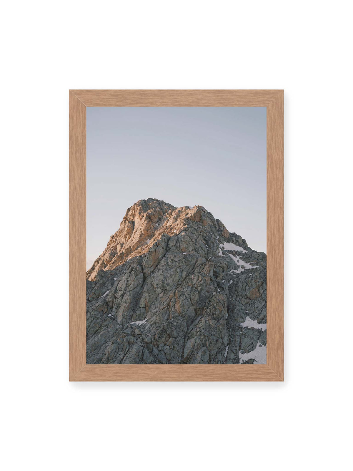 21x30 cm, Eichenrahmen – Massiver grauer Felsgipfel mit kleinen Schneefeldern vor einem weiten blassblauen Himmel.
