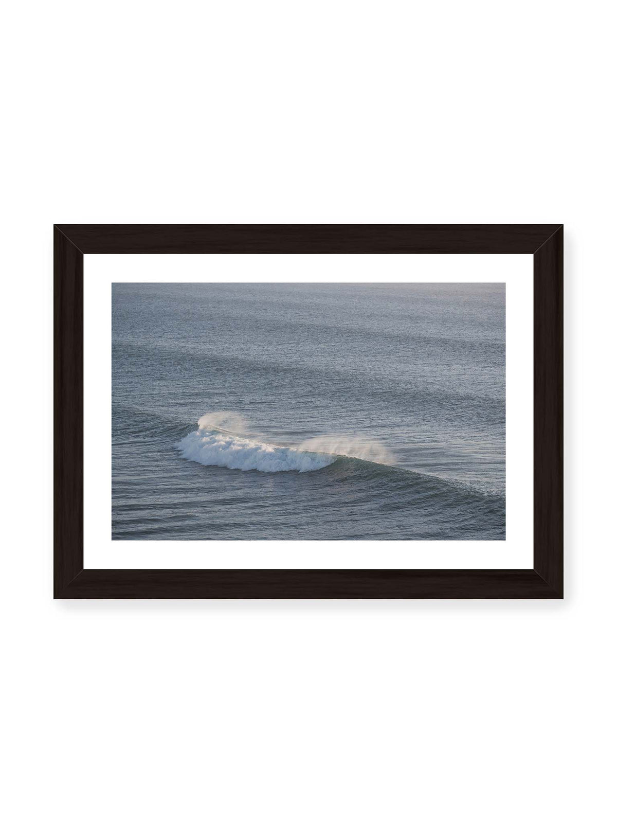30x21 cm, weißer Galerie-Rand, schwarzer Rahmen – Brechende Welle mit weißem Schaum und feiner Gischt auf einer weiten blau-grauen Wasserfläche.
