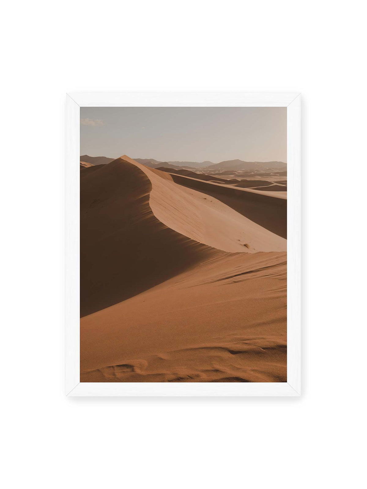 30x40 cm, weißer Rahmen – Geschwungene Sanddünen mit warm beleuchteten Kämmen und tiefen Schatten vor einem hellen Himmel.