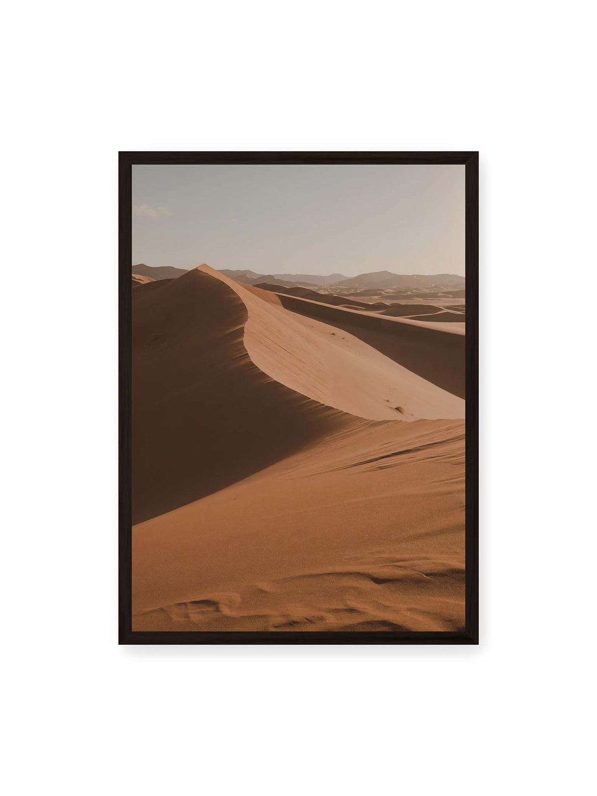 50x70 cm, schwarzer Rahmen – Geschwungene Sanddünen mit warm beleuchteten Kämmen und tiefen Schatten vor einem hellen Himmel.