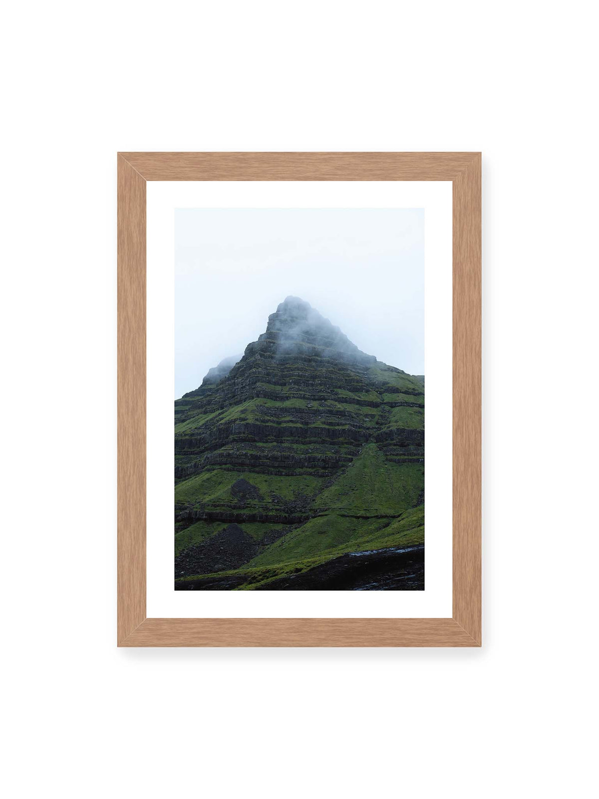 21x30 cm, weißer Galerie-Rand, Eichenrahmen – Steiler grüner Berg mit dunklen Felsbändern, dessen Gipfel in dichtem Nebel verschwindet.