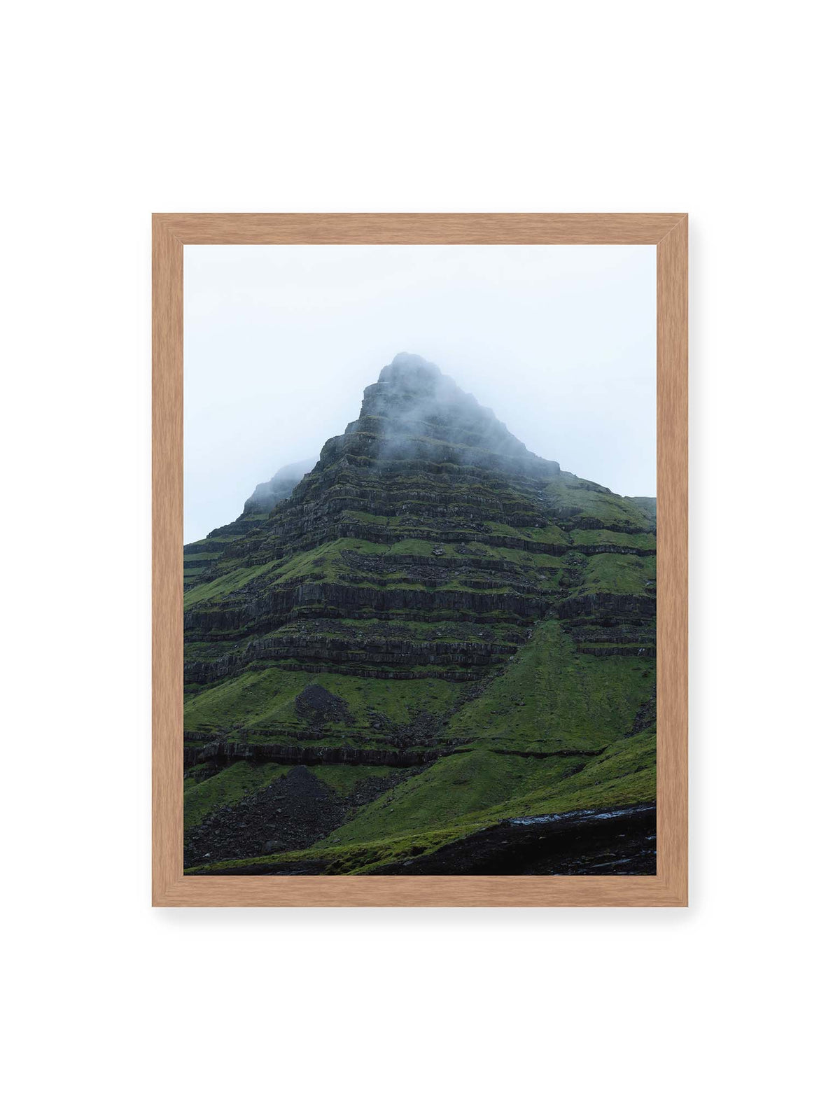 30x40 cm, Eichenrahmen – Steiler grüner Berg mit dunklen Felsbändern, dessen Gipfel in dichtem Nebel verschwindet.