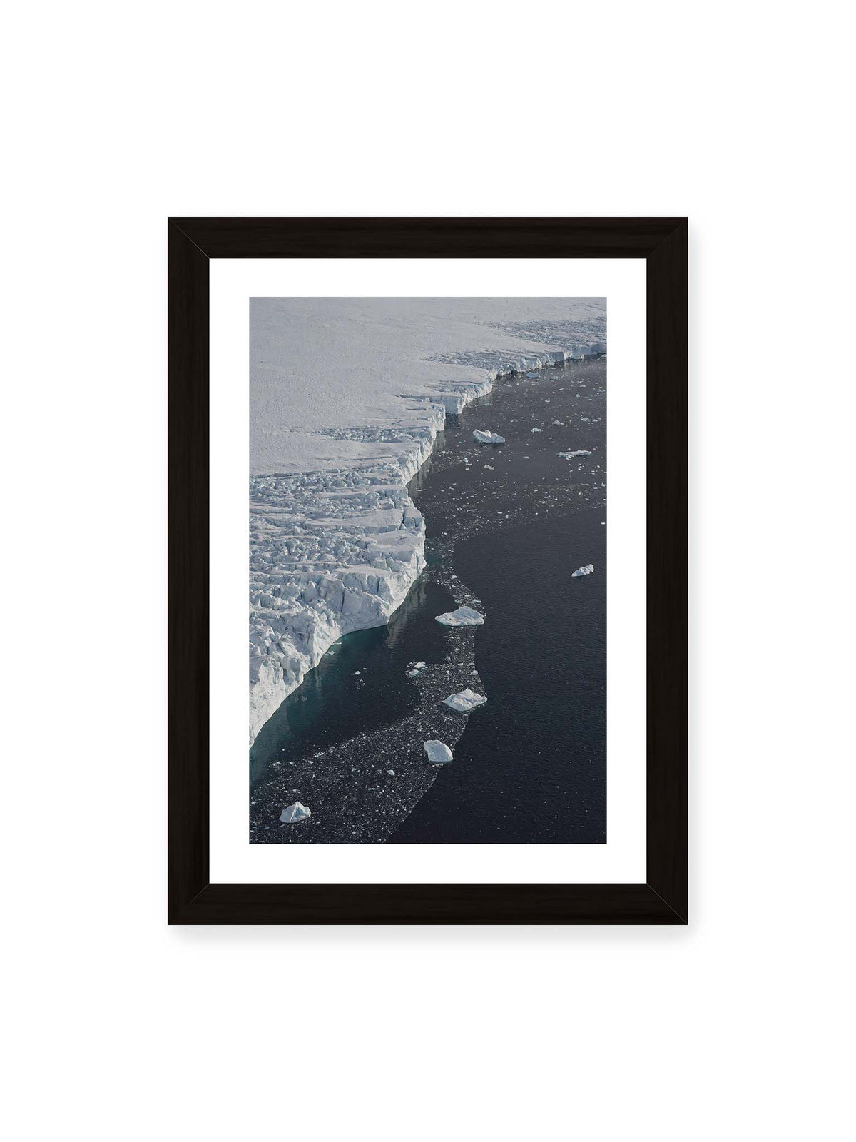21x30 cm, weißer Galerie-Rand, schwarzer Rahmen – Helle Eisfläche mit geschwungener Kante an dunklem Wasser, auf dem einzelne Eisstücke treiben.