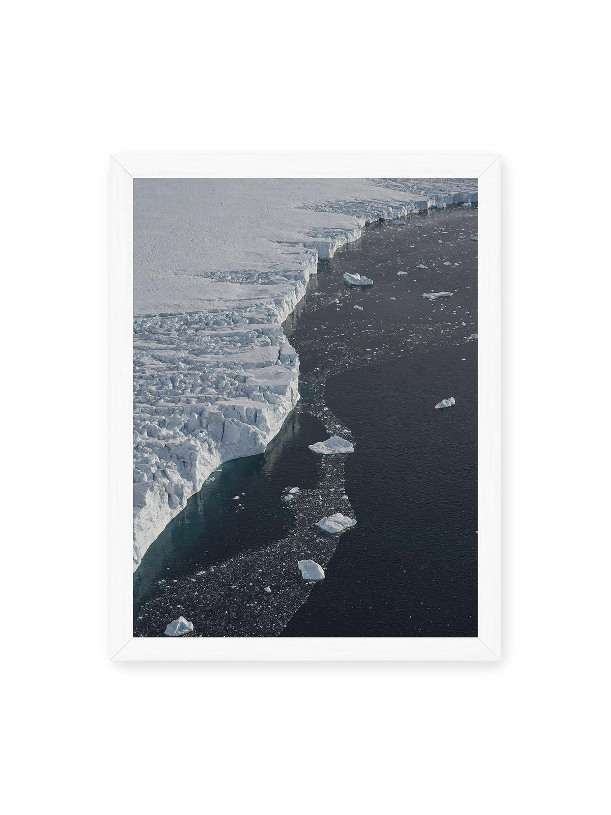 30x40 cm, weißer Rahmen – Helle Eisfläche mit geschwungener Kante an dunklem Wasser, auf dem einzelne Eisstücke treiben.