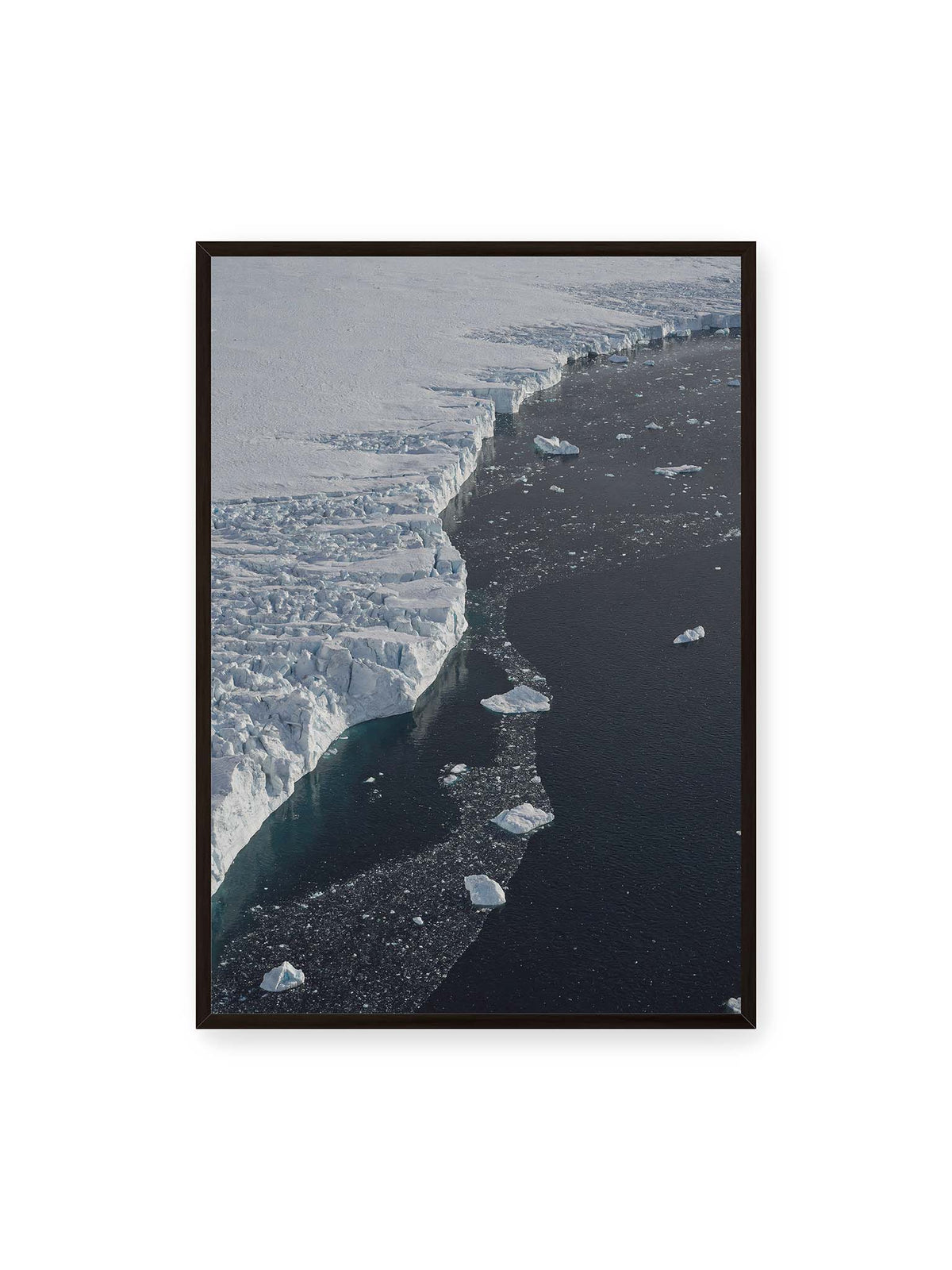 70x100 cm, schwarzer Rahmen – Helle Eisfläche mit geschwungener Kante an dunklem Wasser, auf dem einzelne Eisstücke treiben.